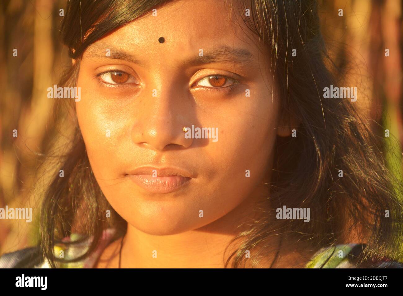 Nahaufnahme eines schönen Mädchens mit einer goldenen Nasennadel und schwarzer Bindi auf ihrer Stirn, selektive Fokussierung Stockfoto