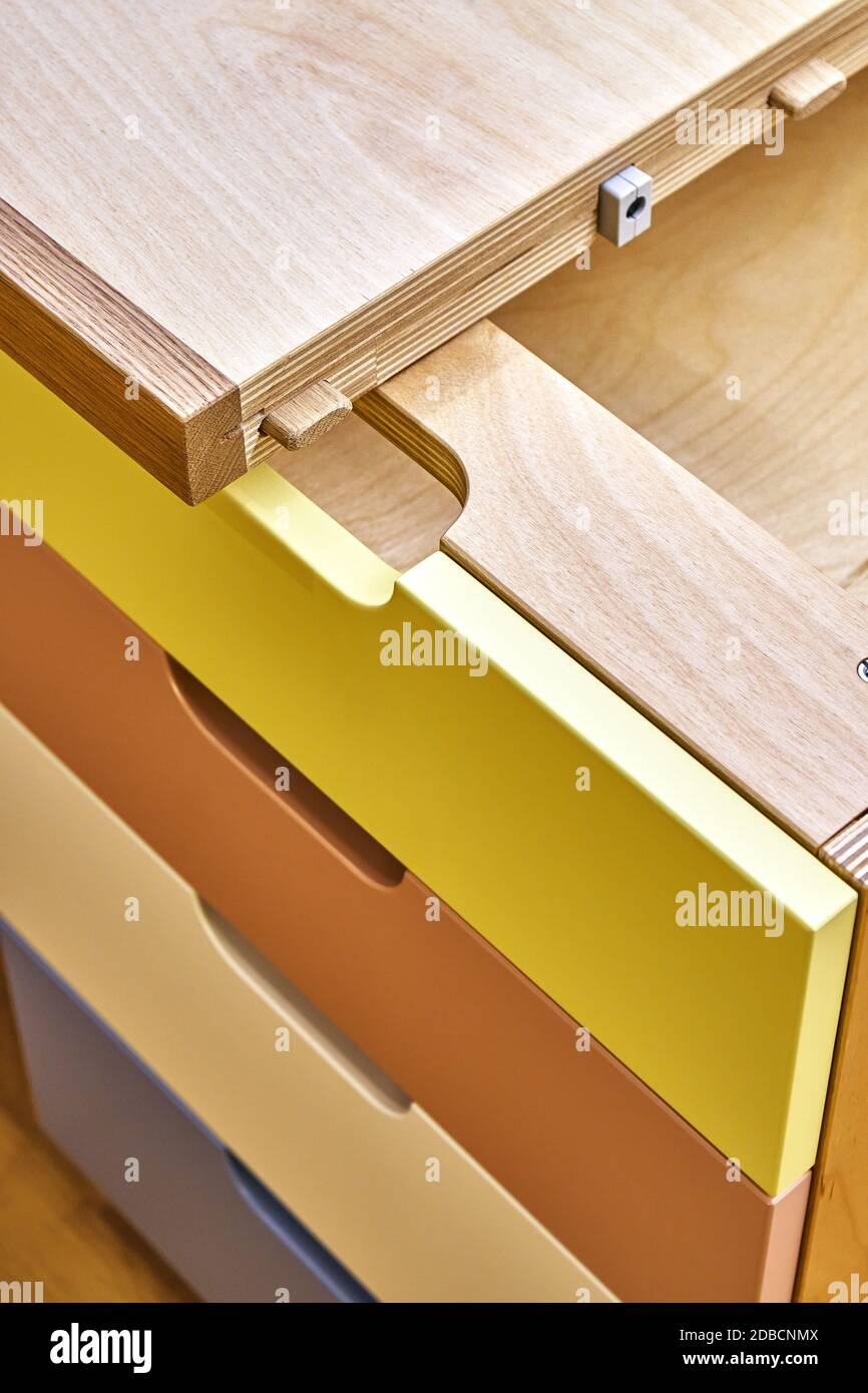 Sperrholz Schreibtisch mit mehrfarbigen Schubladen während der Montage. Fragment des Schreibtisches Stockfoto
