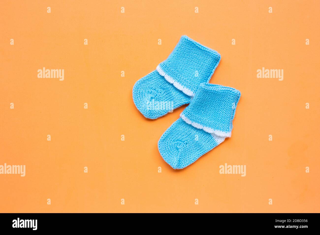 Baby Socken auf orangem Hintergrund. Ansicht von oben Stockfoto