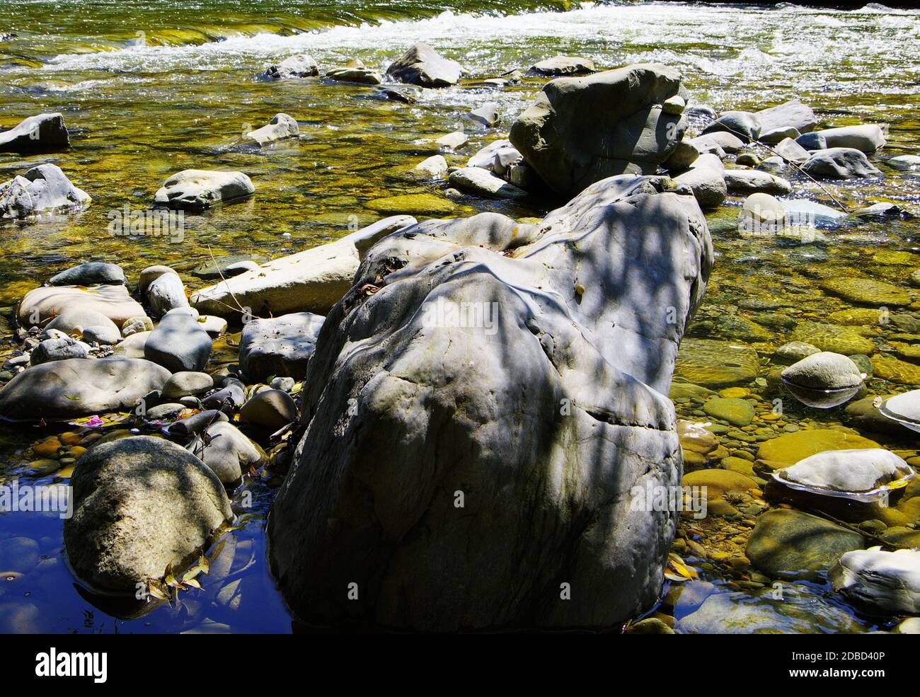 Große und kleine Kieselsteine am Flussufer Stockfoto