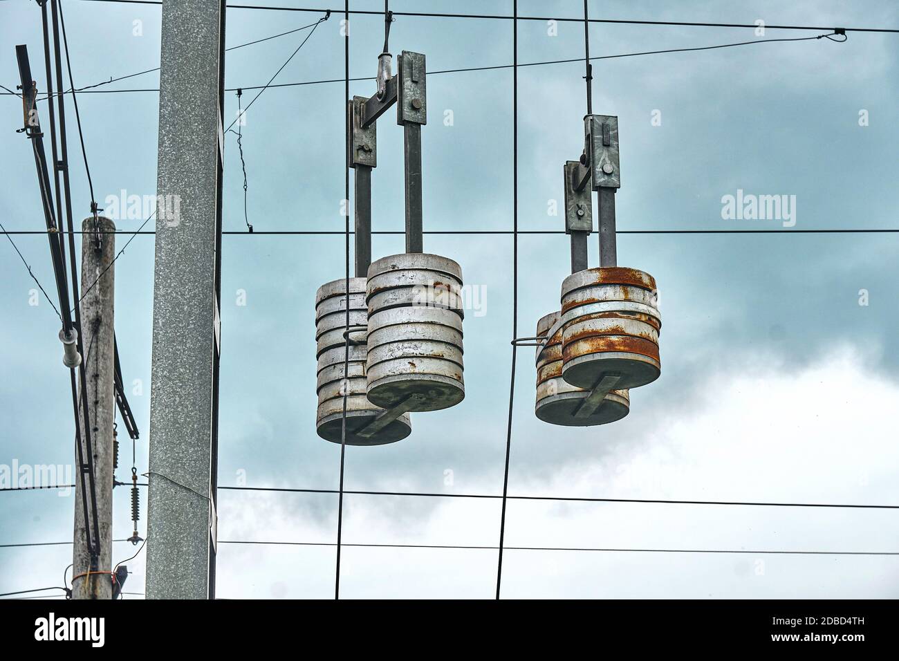 Die Fahrleitungen elektrifizierter Eisenbahnstrecken über dem Kopf gegen einen düsteren Himmel. Drahtspannung Stockfoto