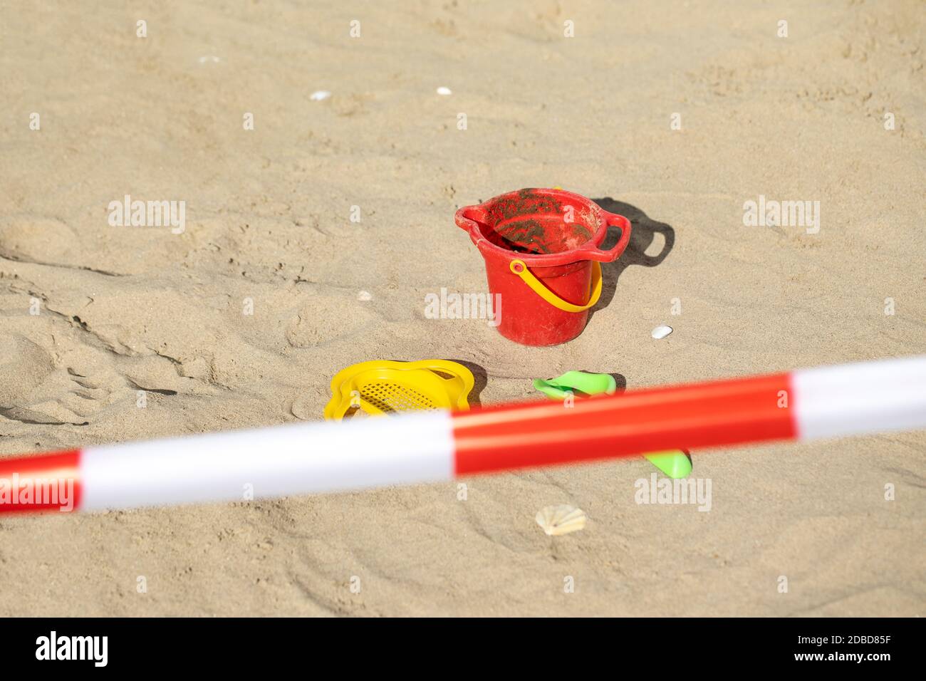 Rote und weiße Barrieren für den Zugang vom Strand verboten Mit Sand und Spielzeug Stockfoto