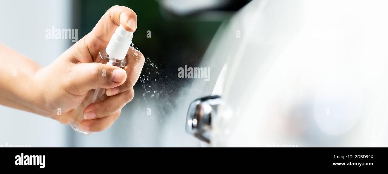 Panorama Web Banner, Auto Reinigung mit Handsprühen Alkohol, Desinfektionsmittel Spray auf Autotür Griff für die Sicherheit zu verhindern und vor Infektionen zu schützen o Stockfoto