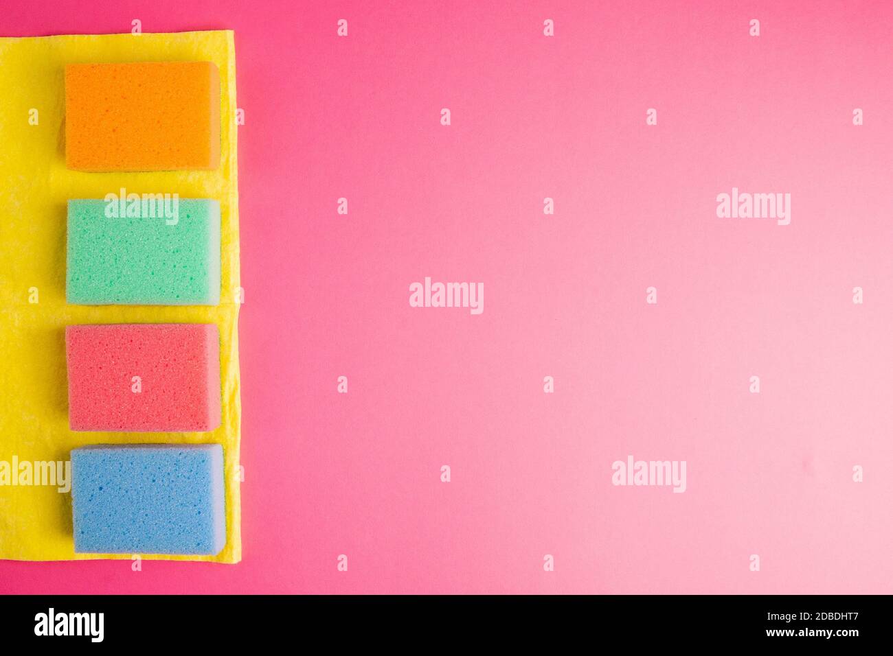 Buntes Reinigungsset für verschiedene Oberflächen in Küche, Bad und anderen Räumen. Leere Stelle für Text oder Logo auf rosa Hintergrund. Reinigungsservice c Stockfoto