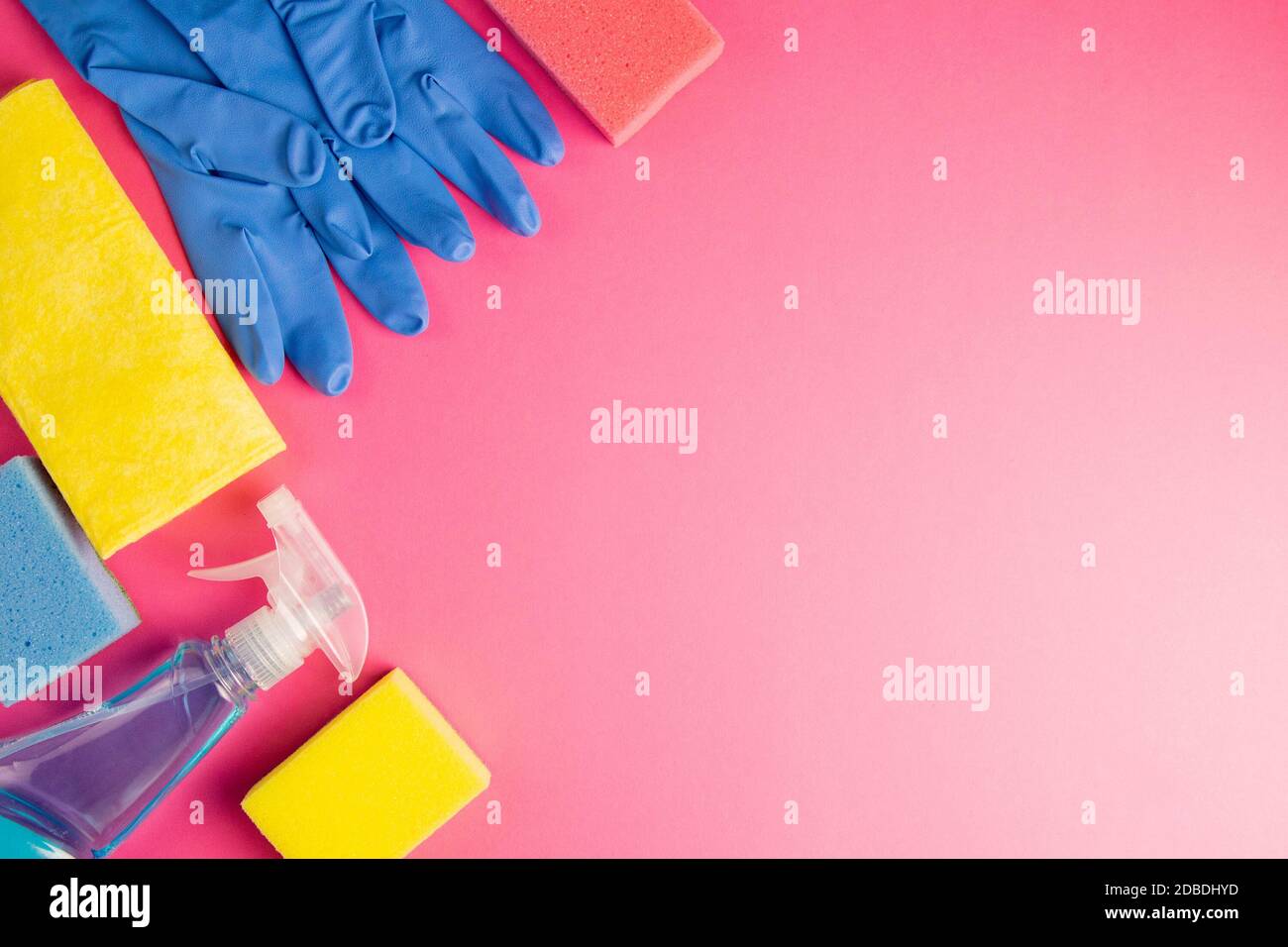 Buntes Reinigungsset für verschiedene Oberflächen in Küche, Bad und anderen Räumen. Leere Stelle für Text oder Logo auf rosa Hintergrund. Reinigungsservice c Stockfoto