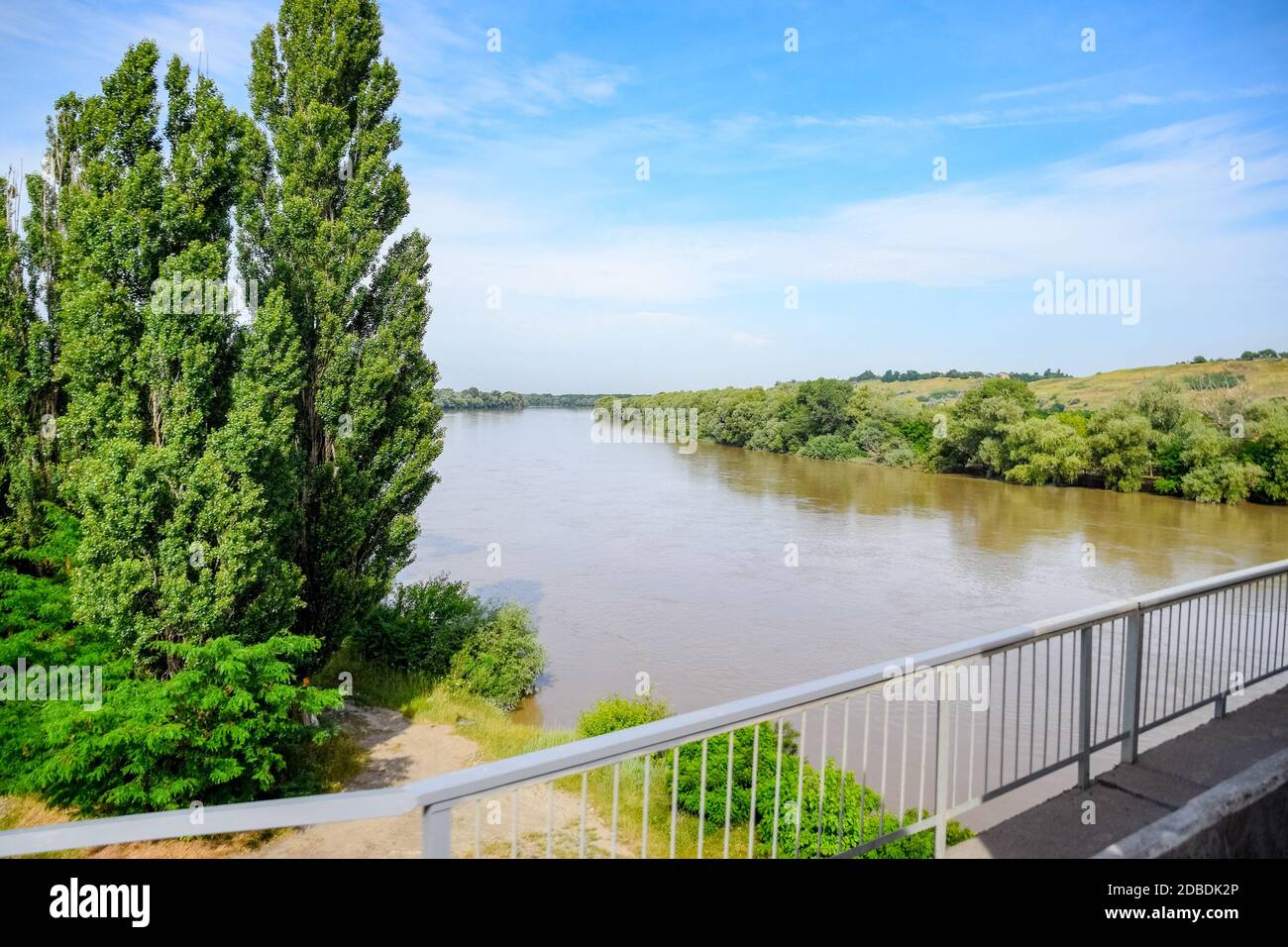 Über die Brücke über den Fluss. Die Landschaft des Flusses, die Oberfläche und die Bäume der Wasserfläche des Flusses. Stockfoto