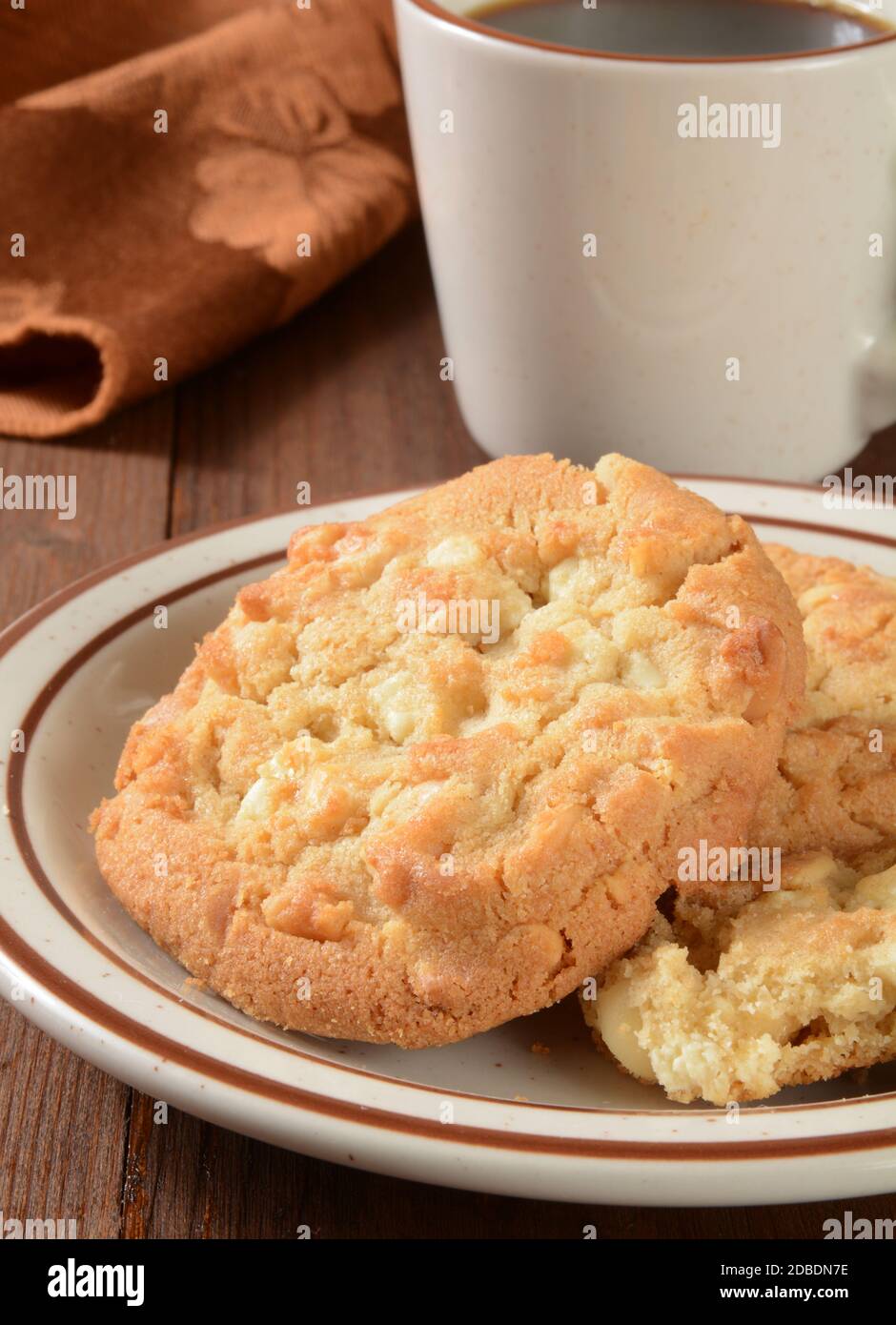 Gourmet-Macadamia-Nuss-Kekse und eine Tasse Kaffee Stockfoto