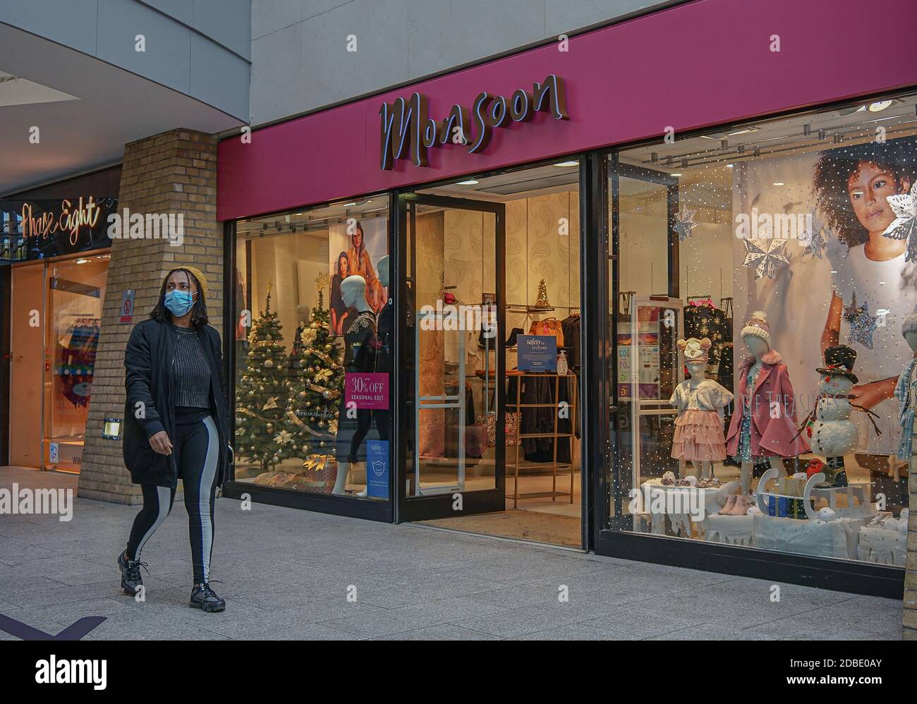 Belfast, Großbritannien. November 2020. Eine Frau mit Gesichtsmaske geht an einem Monsoon-Laden vorbei. Kredit: SOPA Images Limited/Alamy Live Nachrichten Stockfoto