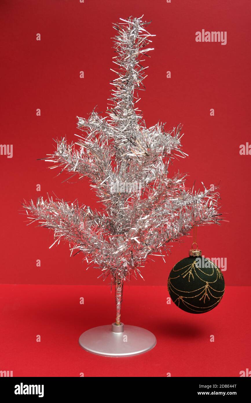 Retro Silber Lametta Weihnachtsbaum mit Kugel auf einem roten Hintergrund Stockfoto