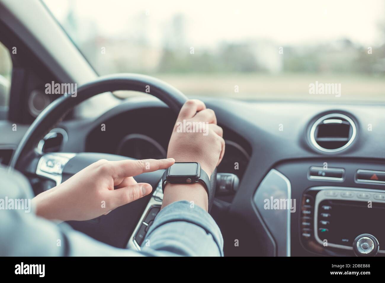 Nahaufnahme einer Frau mit Smart Watch während der Fahrt Auto Stockfoto