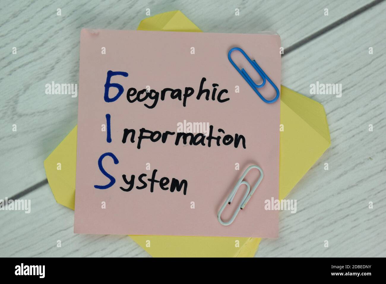 GIS - Geographisches Informationssystem Schreiben Sie auf ein Buch isoliert auf Holztisch. Stockfoto