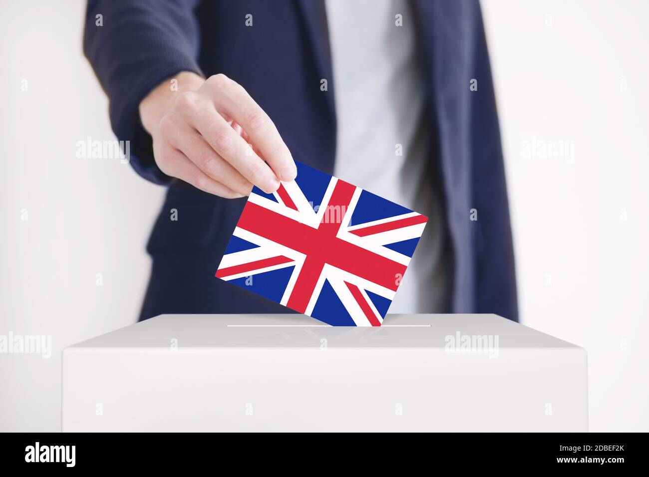 Mann, der mit der britischen FAG eine Abstimmung in eine Wahlbox setzt. Stockfoto