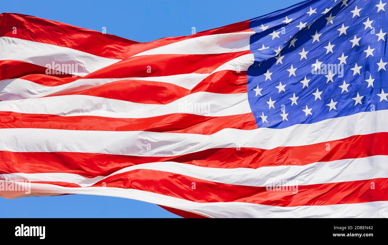 Amerikanische Flagge winkt am blauen Himmel im Wind, Bewegung der US-Flagge in Nahaufnahme, rote weiße blaue Flagge im Freien bei Sonnenlicht. Nationalflagge der Vereinigten Staaten von Amerika. USA Stars und Stripes Stockfoto