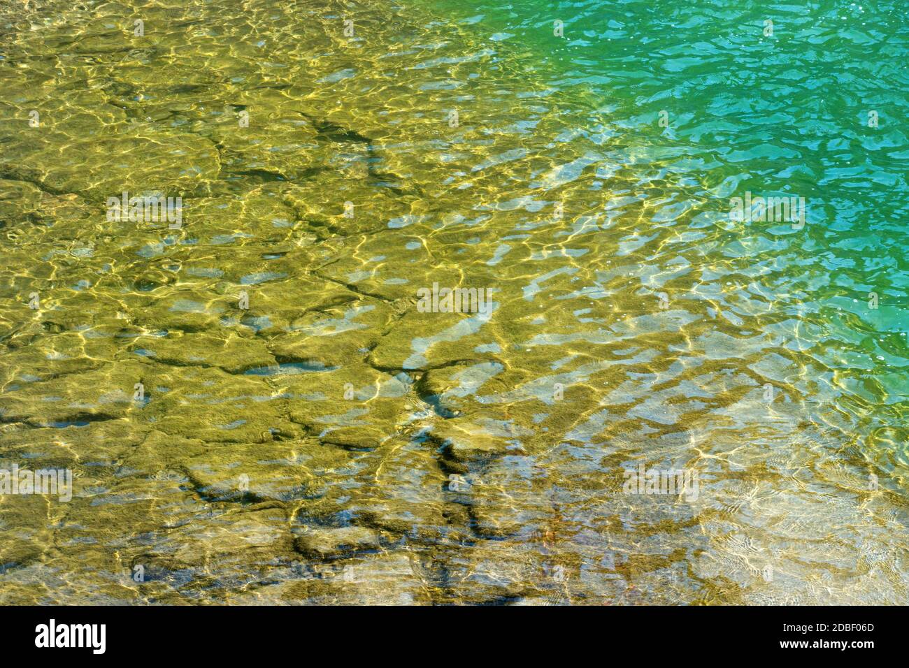 Flaches, schimmerndes Wasser an einem befestigten Ufer Stockfoto