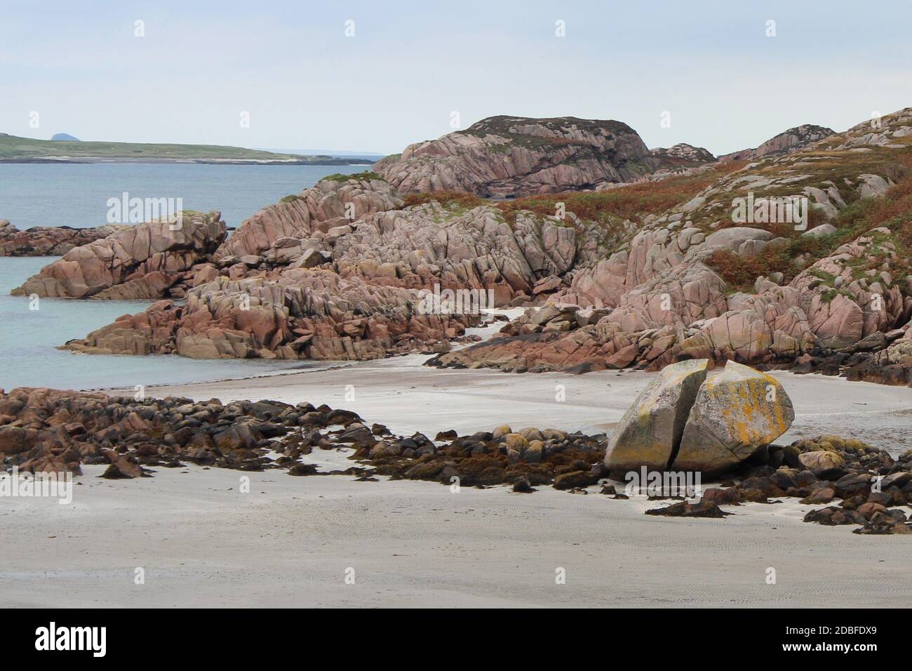 An der Küste des schottischen Fionnphort liegt ein gesplitter Granitfelsen Stockfoto