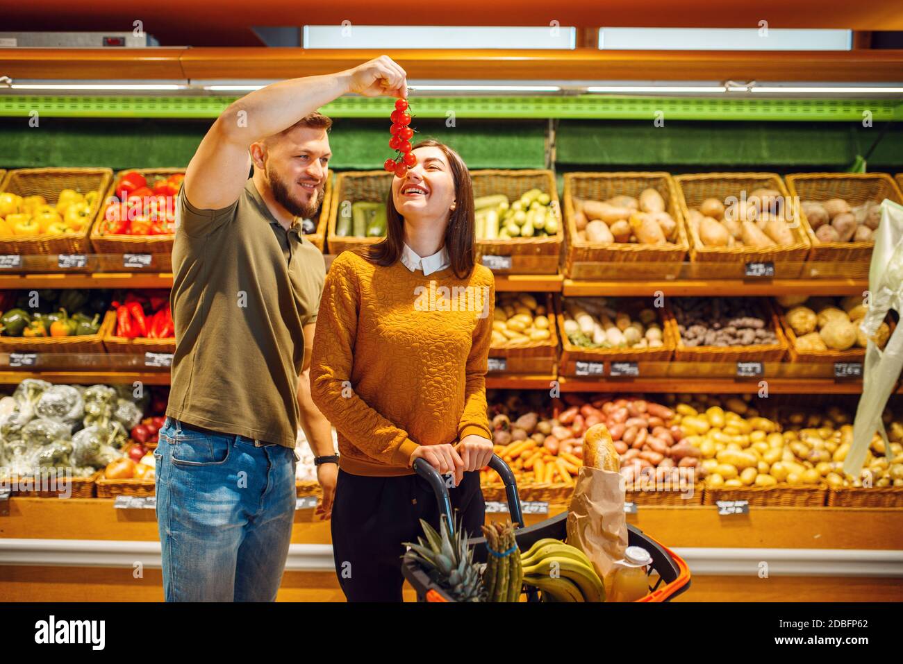 Paar mit Korb im Supermarkt zusammen. Mann und Frau kaufen Obst