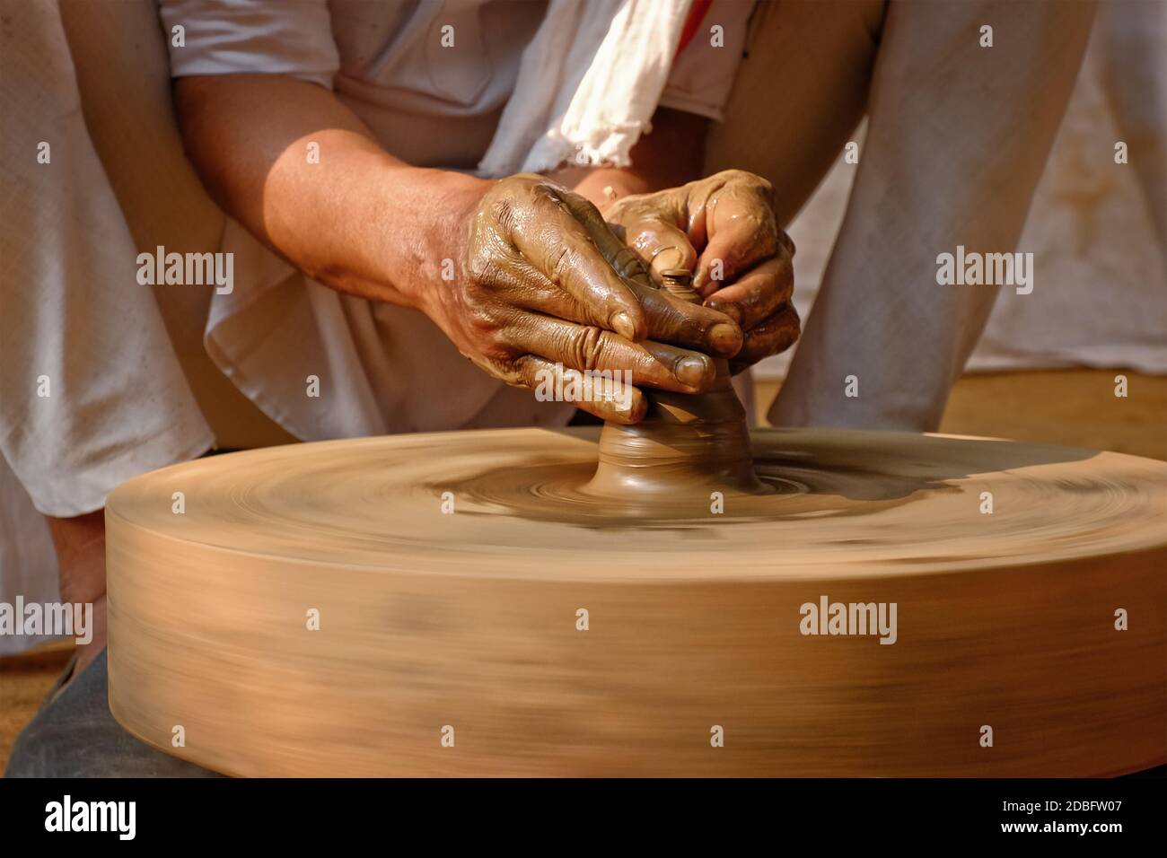 Töpferei - erfahrene Hände des Töpfers Formen der Ton auf Töpferrad Herstellung kleine Flasche. Topfwerfen. Herstellung traditionelle Handwerk indischen Glas, Stockfoto