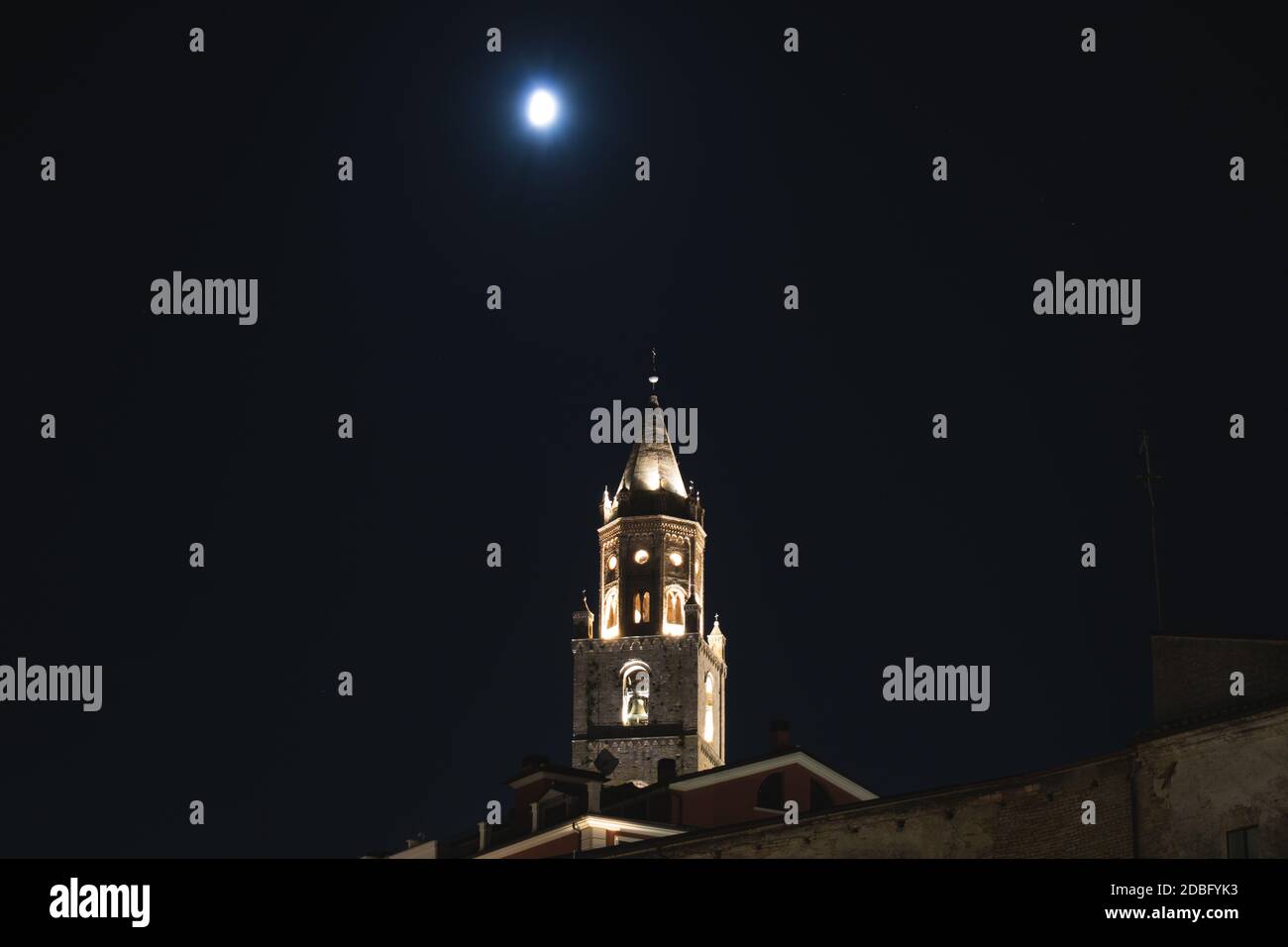 Nachtaufnahme des Parks gegen Himmel und Mond mit Gothic Glockenturm und Blätter Stockfoto