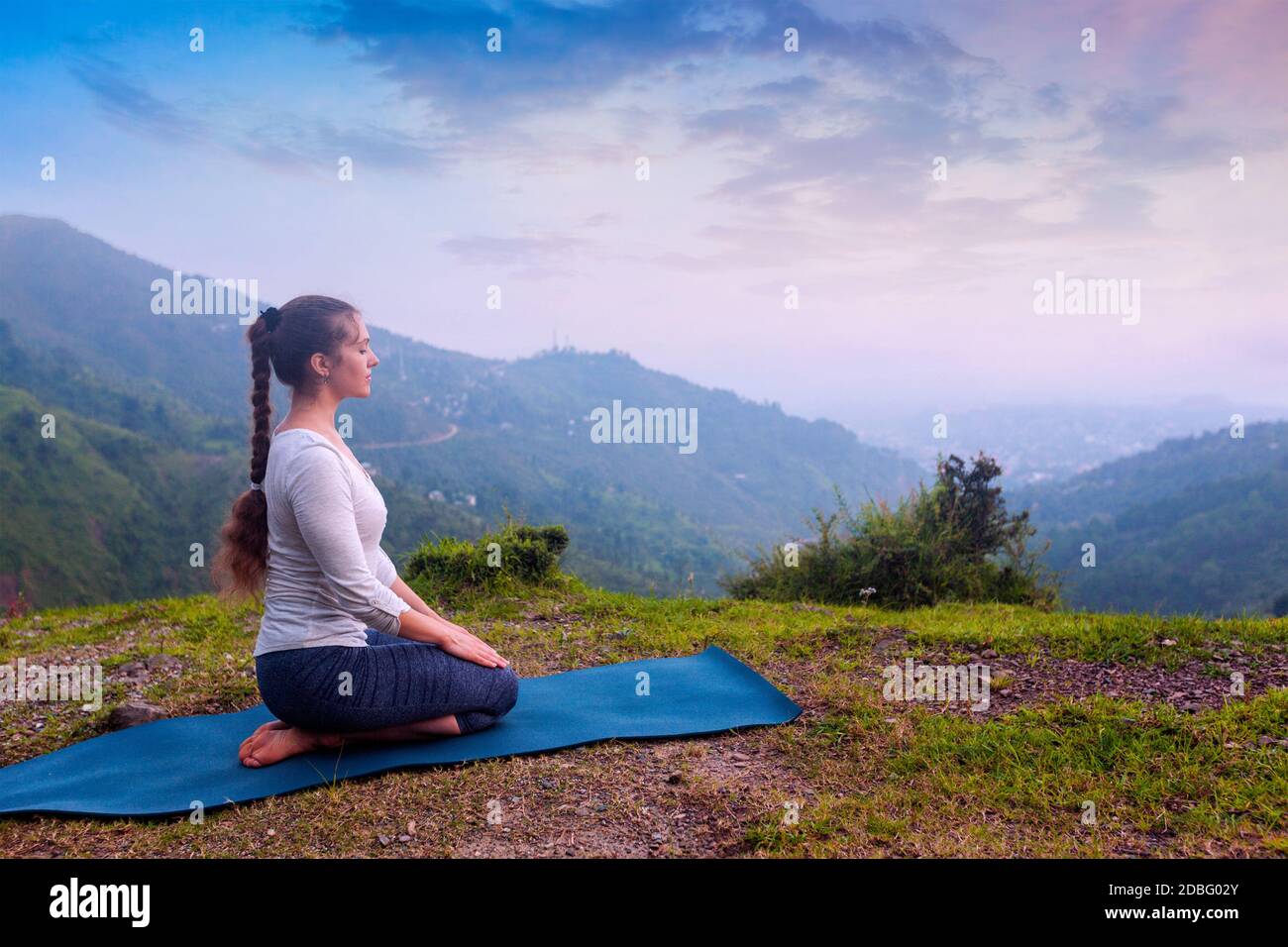Yoga-Übung im Freien - Frau macht Yoga Asana Virasana (Vajrasana) Hero Pose im Himalaya in Indien bei Sonnenuntergang Stockfoto