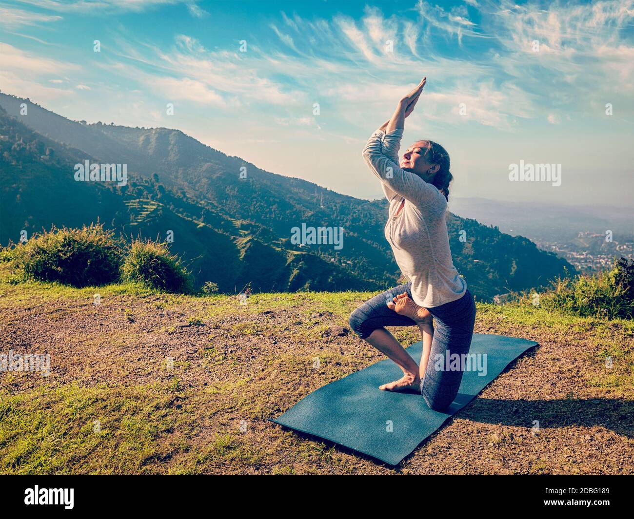 Vintage Retro-Effekt Hipster Stil Bild von Frau tun Ashtanga Vinyasa Yoga Fortgeschrittene schwer Asana Vatayanasana (Pferdehaltung) Im Freien im Himalaya Stockfoto