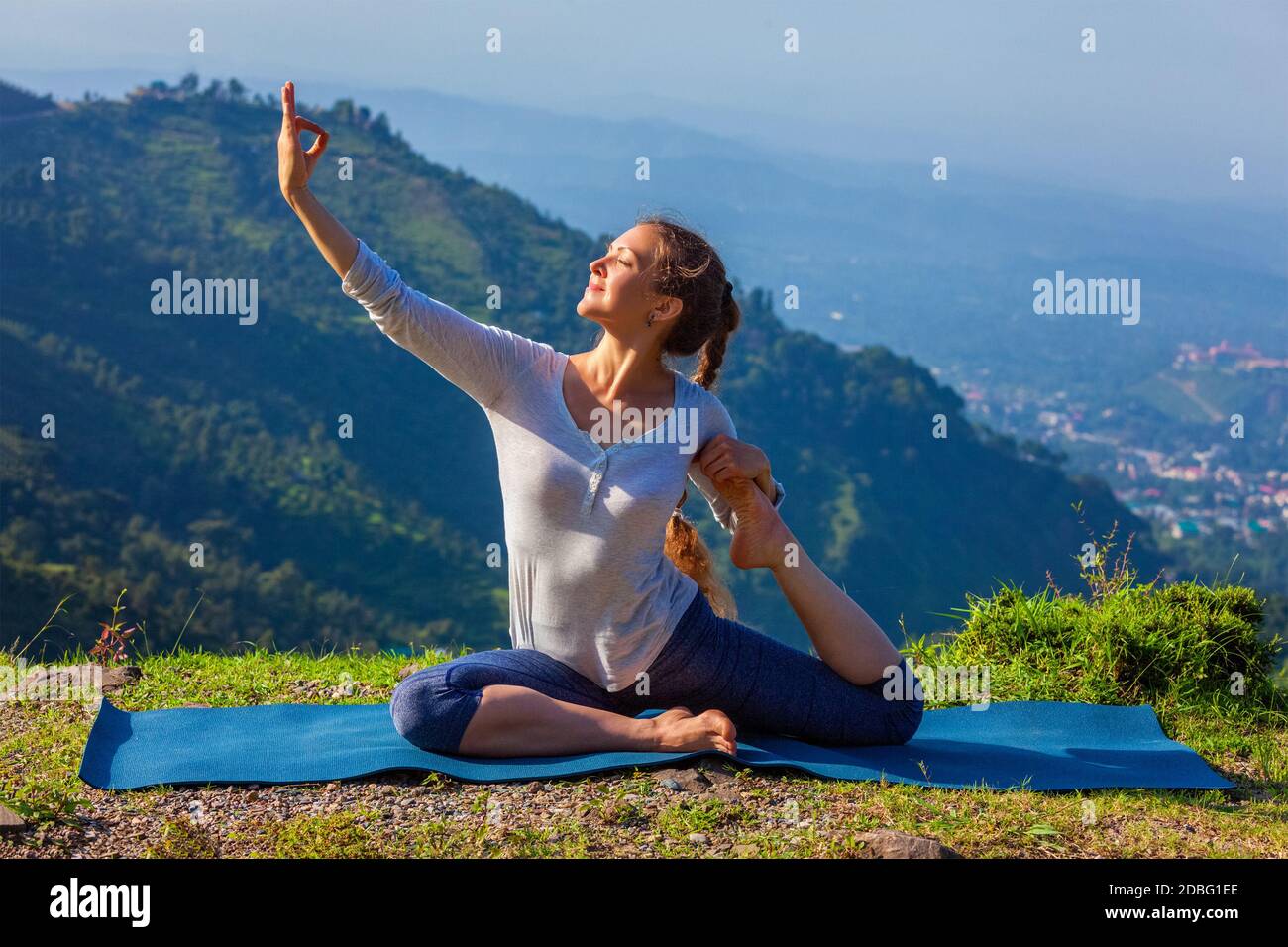 Yoga im Freien - junge sportliche fit Frau Stretching Yoga asana Eka pada rajakapotasana - einbeinige Königstaube Pose in Himalaya Berge, Indien Stockfoto