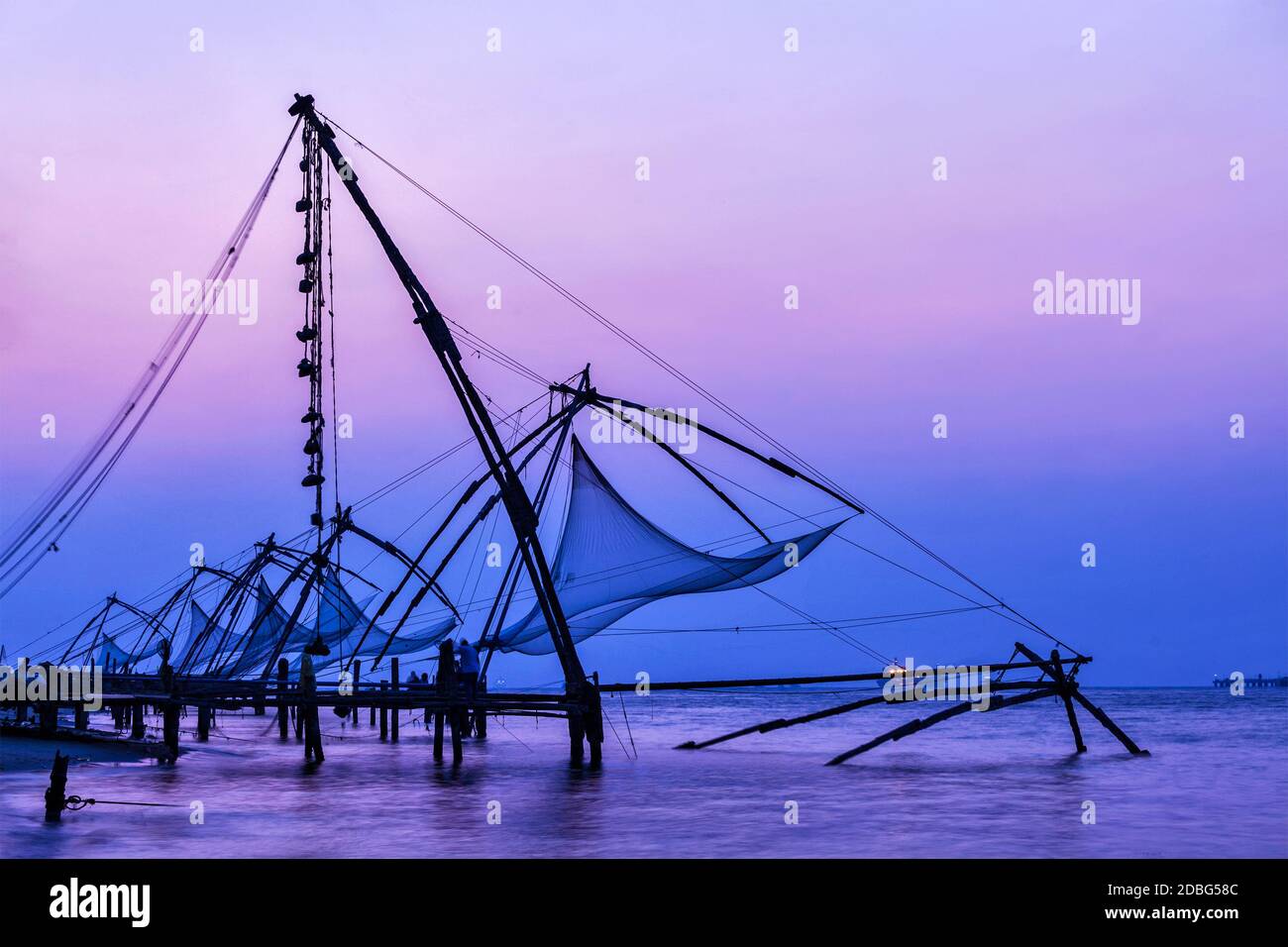 Kochi chinesische Fischnetze bei Sonnenuntergang in Fort Kochin, Kochi, Kerala, Indien Stockfoto