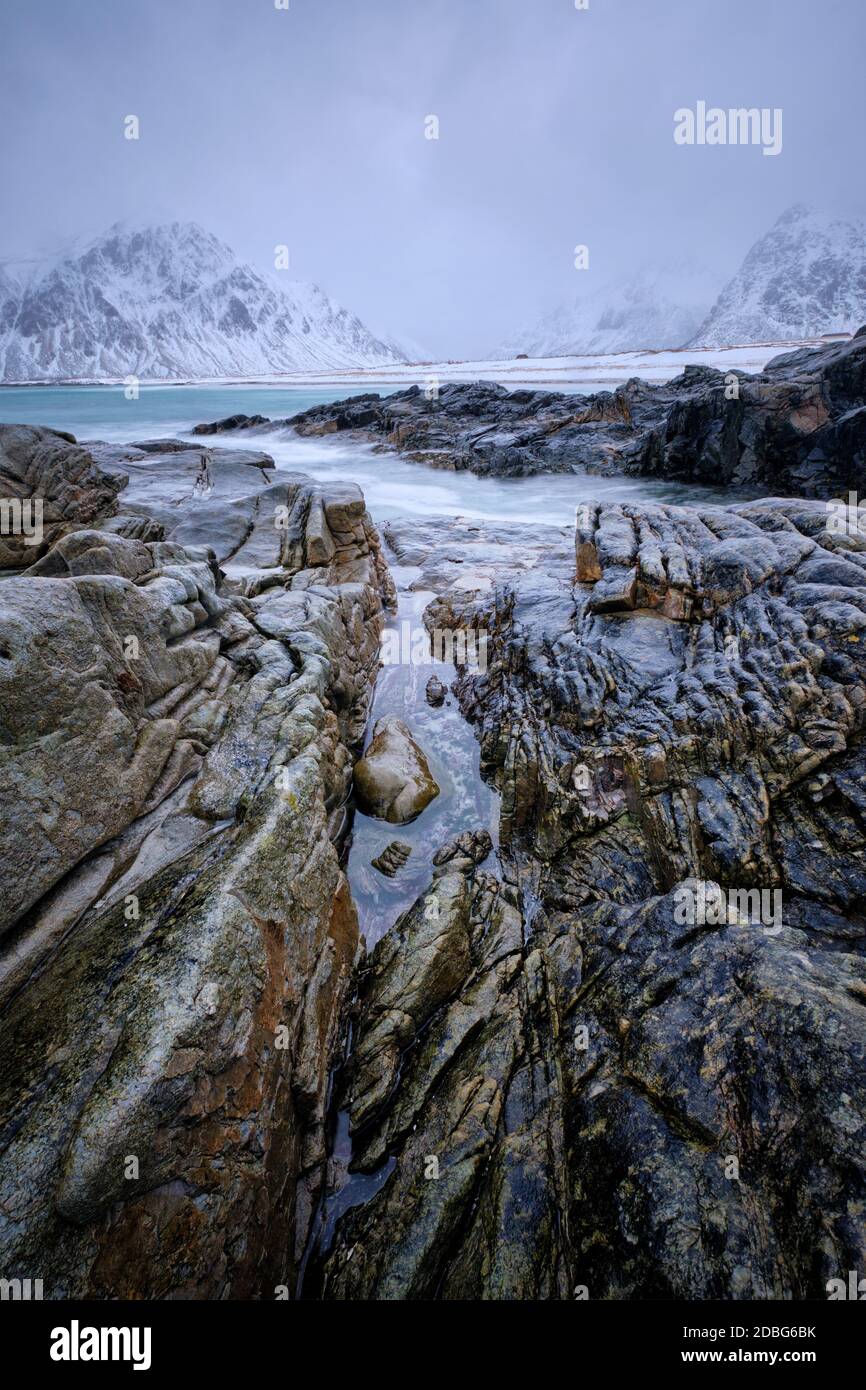 Wellen und Felsen an der Küste des norwegischen Meeres im Fjord. Skagsanden Strand, Flakstad, Lofoten Inseln, Norwegen. Bewegungsunschärfe bei langer Belichtung Stockfoto