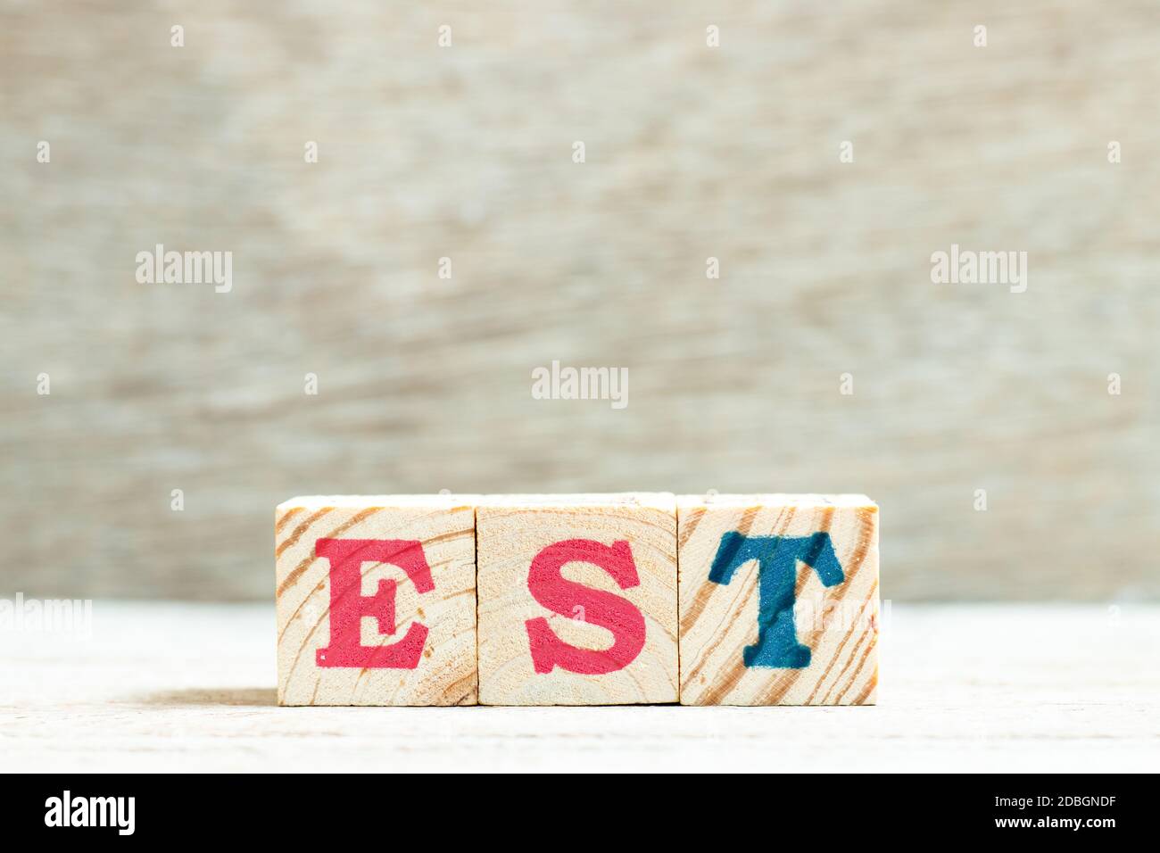 Buchstabe im Wort EST (Abkürzung für etablierte, geschätzte, östliche Zeitzone, ausgedrückte Sequenzkennzeichnung) auf Holzhintergrund Stockfoto