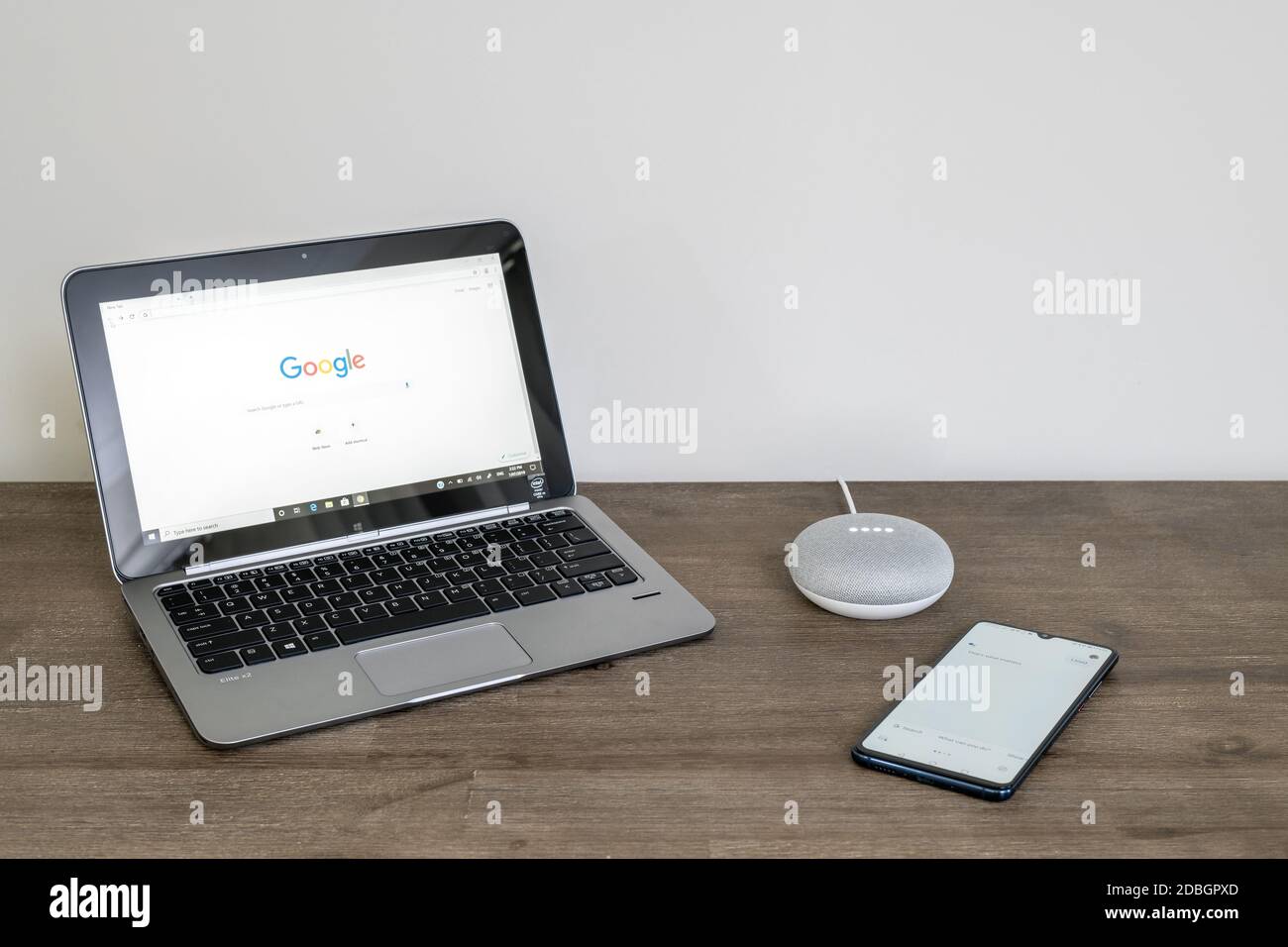 Adelaide, Australien - 7. Juli 2019: Google Home Mini mit HP-Laptop mit Windows 10 und Handy auf dem Tisch neben einander eingerichtet Stockfoto