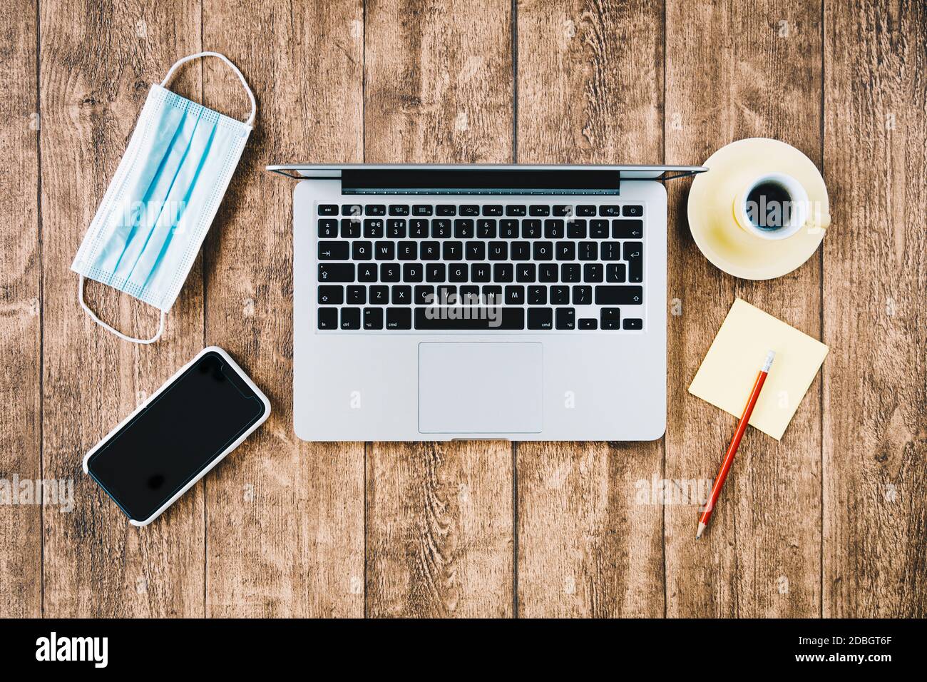 Büro-Arbeitsplatz und Home Office-Schreibtisch während COVID Pandemie. Laptop-Computer mit Gesichtsmask. Stockfoto