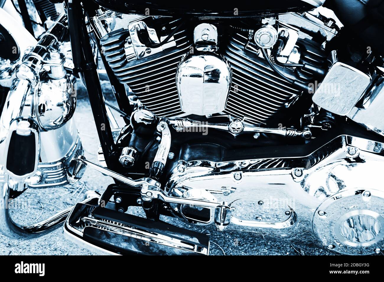 Ein Teil des ordentlichen Motorrads mit Zylinder und viel Chrom in blauem Monochrom Stockfoto