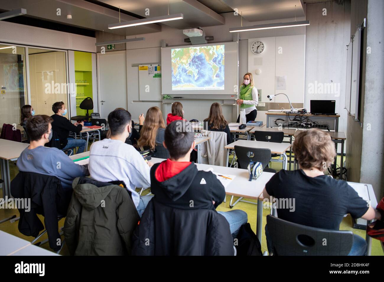 München, Deutschland. November 2020. Lehrerin Meike Wiese steht vor ihren Schülern in einem Geografie-Seminar in der Klasse elf am Staatsgymnasium Trudering. Sowohl die Lehrer als auch die Schüler tragen Mund- und Nasenprotektoren im Unterricht. Quelle: Matthias Balk/dpa/Alamy Live News Stockfoto