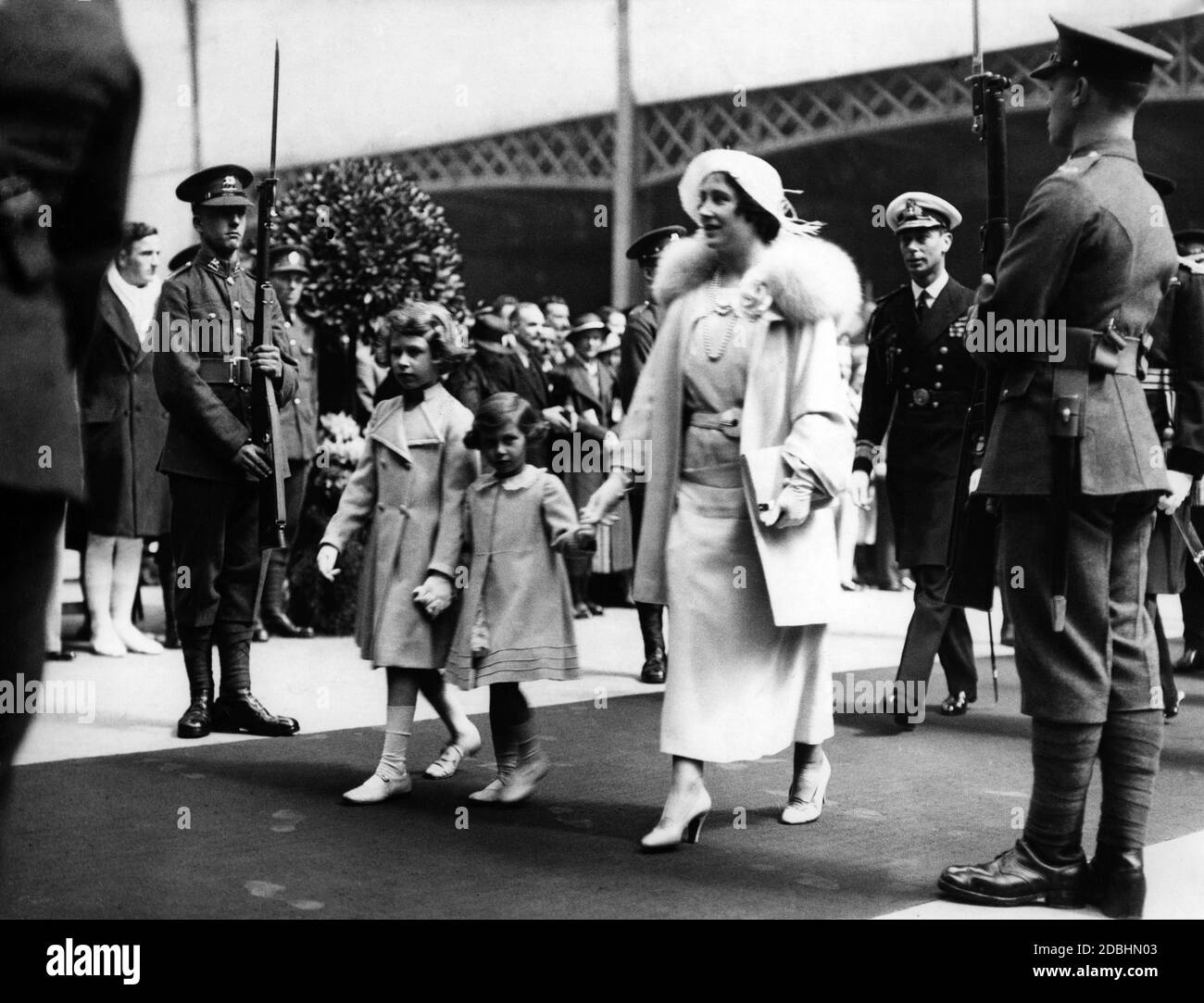 George, der Herzog von York und später König George VI, seine Frau Elizabeth und ihre beiden Töchter, Prinzessin Elizabeth (rechts) und Prinzessin Margaret Rose gehen durch die Garde der Ehre in Olympia in London während des Royal Tournament. Stockfoto