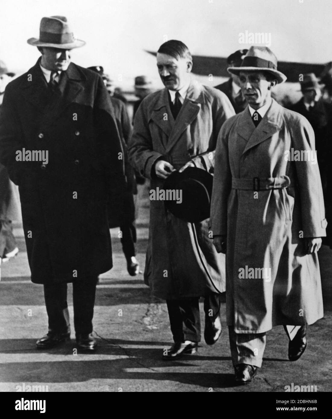 Adolf Hitler wird von Paul von Hindenburg im Tempelhofer Feld in Berlin begrüßt. Dr. Joseph Goebbels läuft neben Hitler. In dieser Zeit hatte Hitler immer eine Hundepeitsche als Zubehör bei sich. Er und Goebbels trugen den Trenchcoat, den Hitler als Kleidungsstück einführte und mit Hilfe dessen versuchte, sich von der Kleiderart der Weimarer Politiker zu distanzieren. Stockfoto