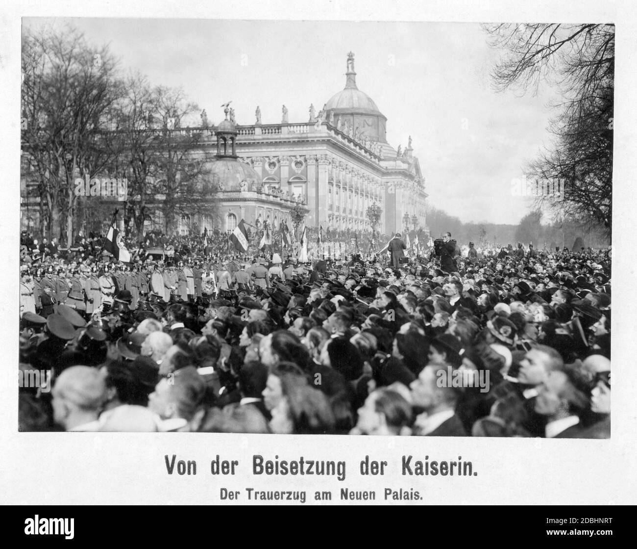 Kaiserin Augusta Victoria wurde am 19. April 1921 im Antikentempel im Schlosspark Sanssouci in Potsdam beigesetzt. Das Foto zeigt die Trauerprozession am Neuen Palast im Park auf dem Weg zum Antikentempel. Auf der rechten Seite des Bildes ist ein Fotograf mit seiner Kamera. Stockfoto