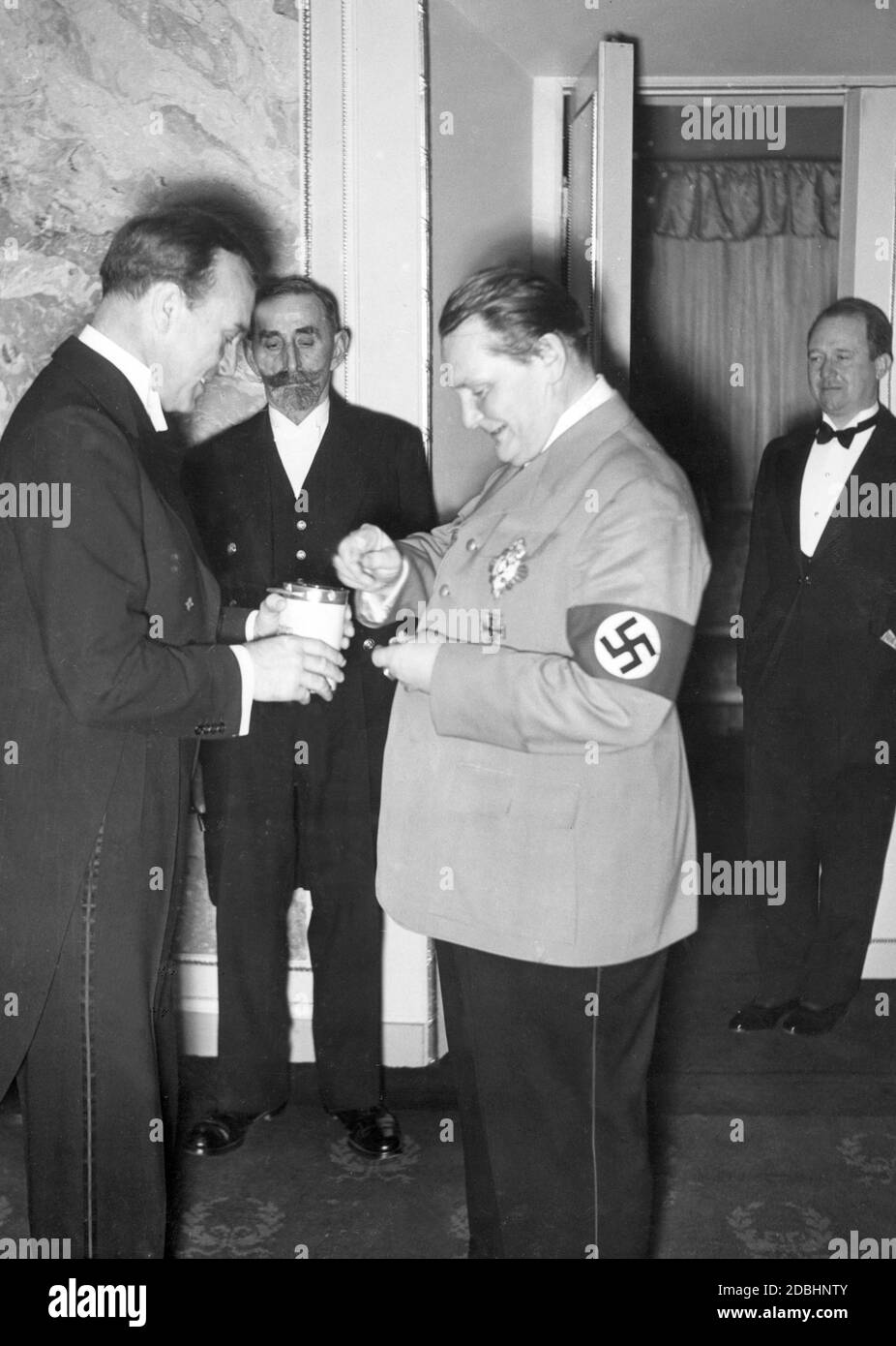 Paul Hartmann überreicht Hermann Göring die Sammelbox der WHW-Spende (rechts). Das Bild entstand bei der Festaufführung zum 150. Jubiläum des Staatlichen Schauspielhauses. Stockfoto