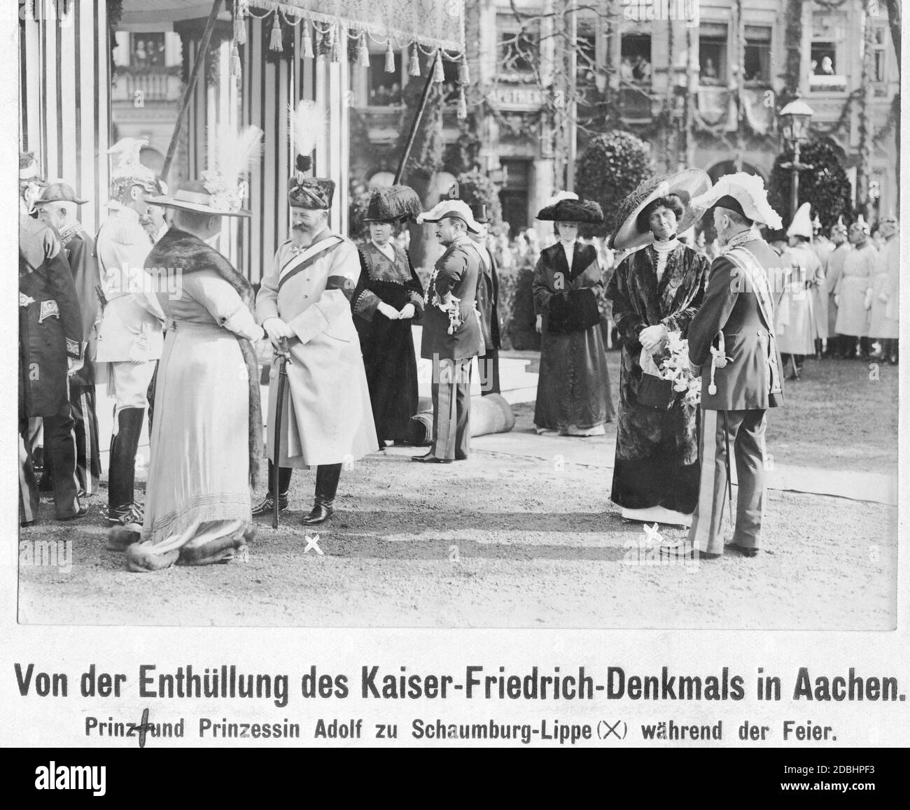 "Am 18. Oktober 1911 wurde das Kaiser-Friedrich-Denkmal auf dem Kaiserplatz in Aachen enthüllt. Unter den Anwesenden war Fürst Adolf von Schaumburg-Lippe (links, mit dem Großkreuz des Württembergischen Kronordens, einer Schärpe und einem Säbel angelehnt) in seiner Uniform des Husarenregiments "König Wilhelm I.". (1. Rheinisch) Nr. 7. Etwas weiter rechts befindet sich seine Frau Prinzessin Viktoria von Schaumburg-Lippe (geboren aus Preußen). Auf der linken Seite ist ein Kuirassier aus dem Regiment der Gardes du Corps in seiner weißen Parade Uniform mit Adlerhelm." Stockfoto