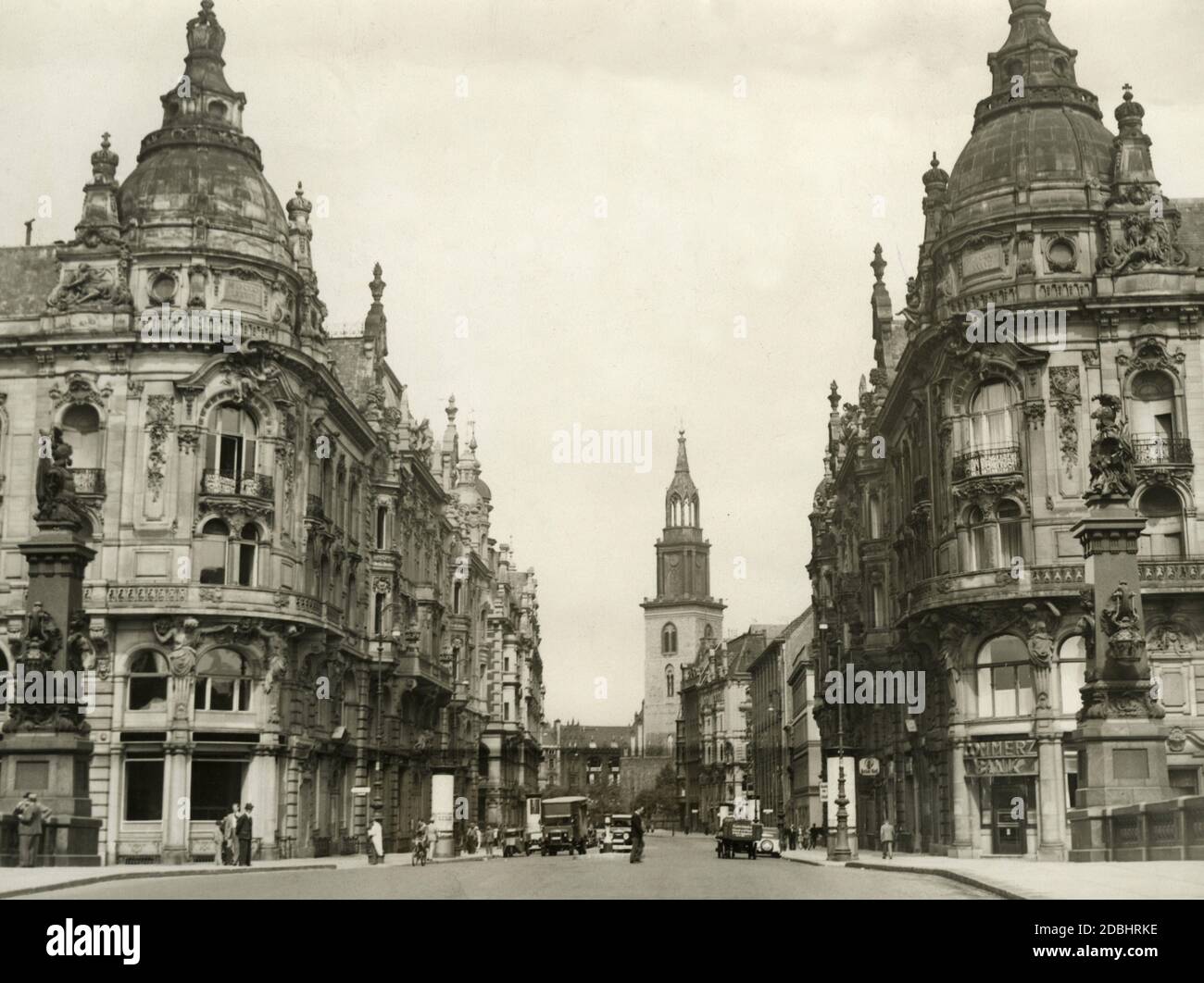 Das Foto von 1938 entstand an der Brücke, die die Spree am Berliner Dom überquert. Sie zeigt die Kaiser-Wilhelm-Allee (heute: Karl-Liebknecht-Straße) und die Marienkirche (im Hintergrund) in Berlin-Mitte. Im Gebäude rechts befindet sich eine Filiale der Commerzbank. Stockfoto