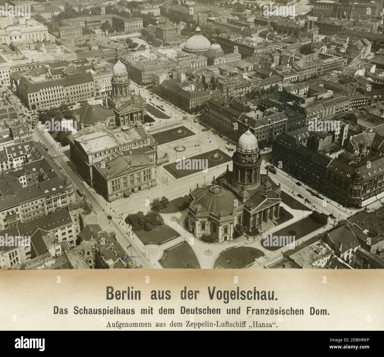 'Das Bild zeigt den französischen und deutschen Dom sowie das Schauspielhaus am Gendarmenmarkt in Berlin. Der Platz wird von der Charlottenstraße und der Markgrafenstraße begrenzt und kreuzt sich mit der Mohrenstraße, Taubenstraße, Jaegerstraße, Franzoesischer Straße, Behrenstraße und ganz im Hintergrund mit dem Prachtboulevard unter den Linden. Dort befinden sich auch die Humboldt-Universität und der St. Hedwigs-Dom am Bebelplatz. Das Bild wurde vom Zeppelin LZ 13 ''Hansa''' aufgenommen. Stockfoto