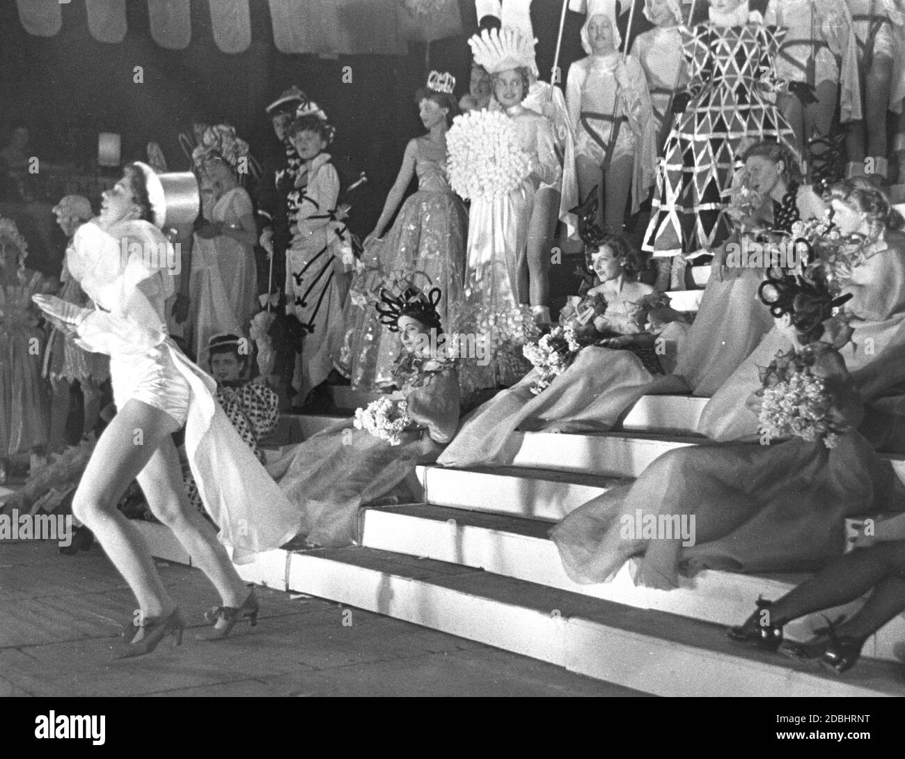 Die Textil- und Modeschule der Stadt Berlin (heute: Hochschule für angewandte Wissenschaften Berlin) hat beim Presseball des Jahres 1938 in Berlin eine Revue gegeben. Links im Bild tanzt eine Stepptänzerin. Stockfoto