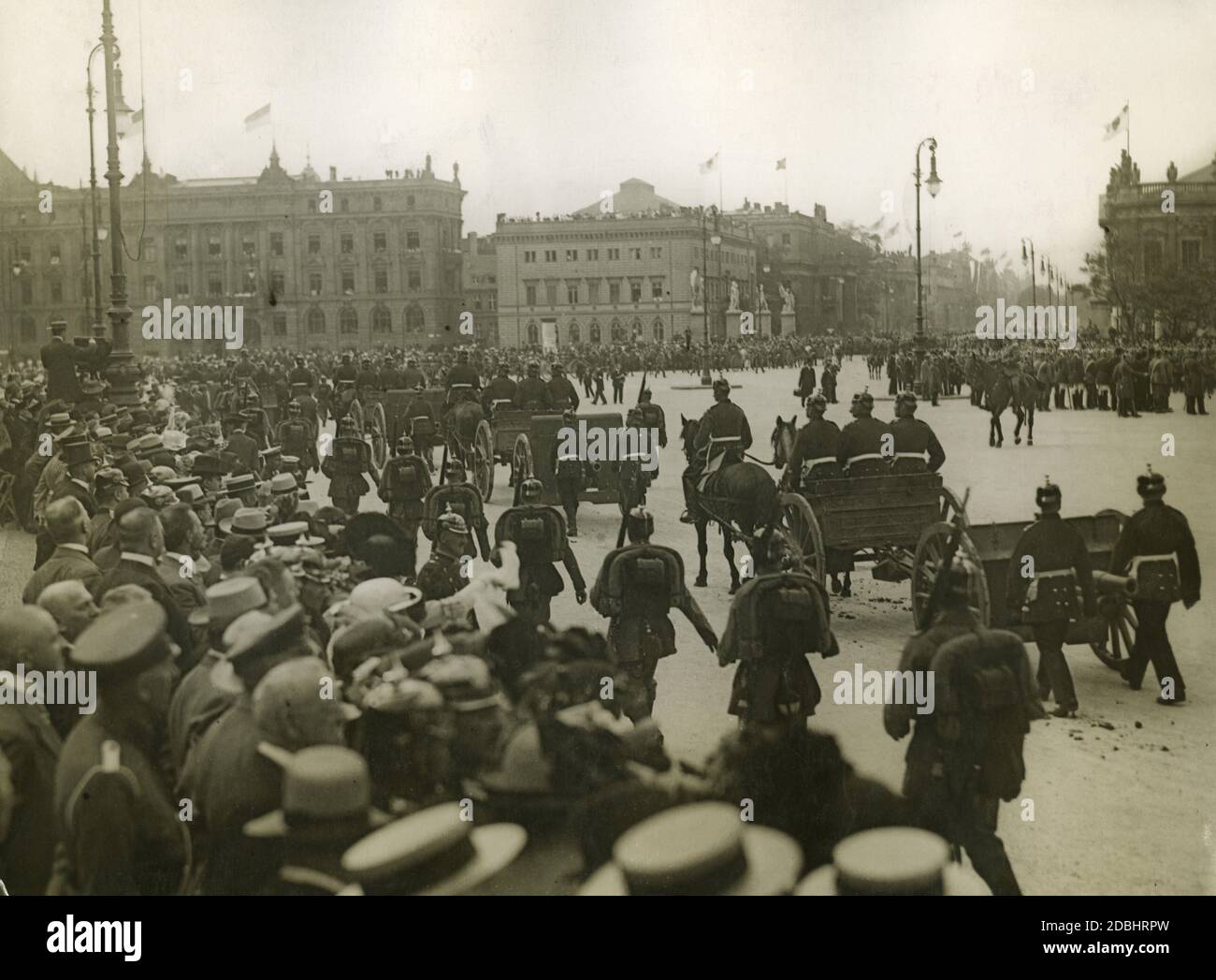 Kurz nach Ausbruch des Ersten Weltkriegs reiten Artilleriesoldaten mit Pferdegewehren durch Berlin. Das sind eingefangene Waffen. Die Soldaten sind auf der Museumsinsel. Im Hintergrund die Alte Kommandantur (Mitte) und das Kronprinzenpalais (dahinter rechts). Links in angehobener Position befindet sich ein Fotograf mit Kamera. Stockfoto