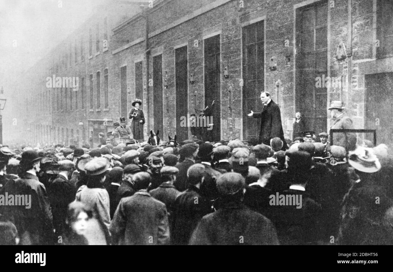Die irische Frauenrechtlerin Mary Maloney (links) unterbricht die Wahlkampfrede des Parlamentskandidaten Winston Churchill (rechts) vor Fabrikarbeitern in Dundee mit lautem Glockengeläut. Stockfoto