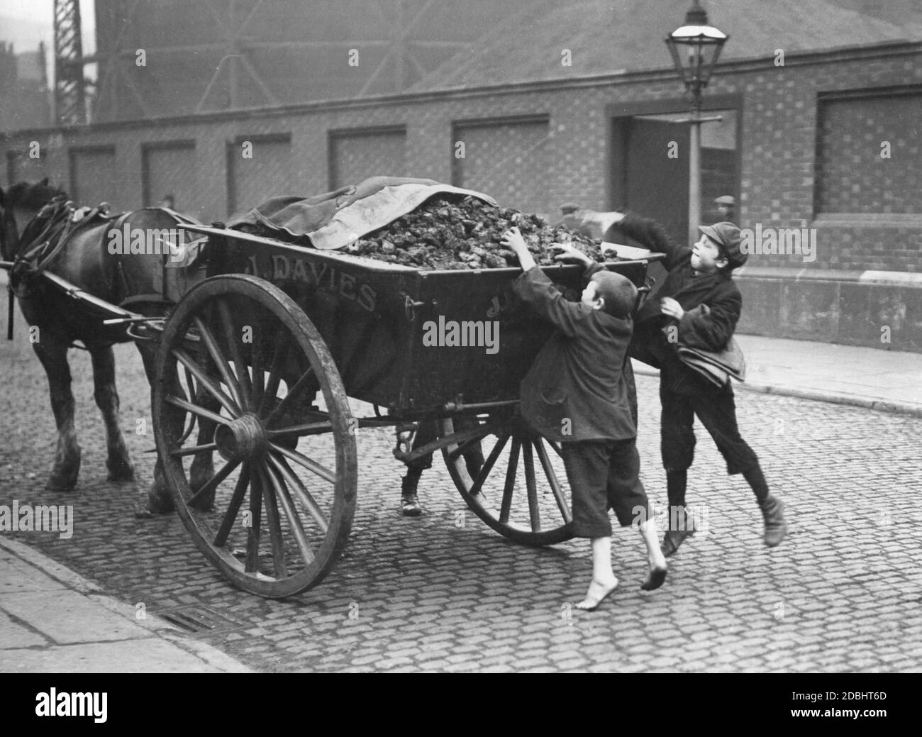 Zwei Straßenjungen stehlen Kohle aus einem Wagen in Manchester. Stockfoto