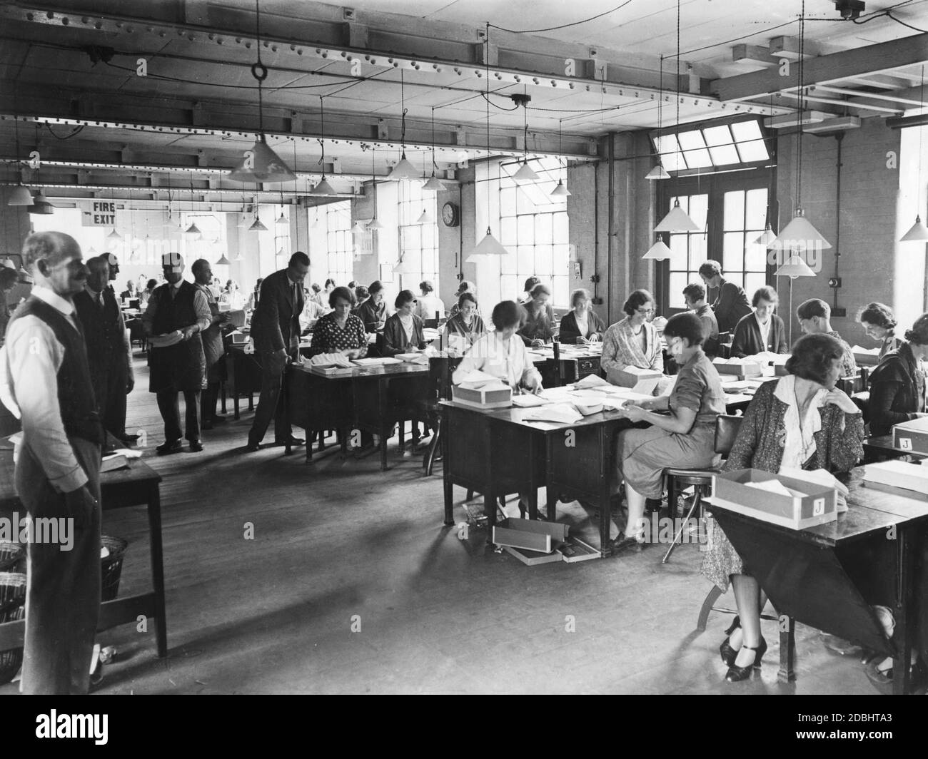 Die Beschäftigten der Regierungsdruckerei bearbeiten Formulare, die die Anleihegläubiger über die Zinsänderung anlässlich der Kriegskreditumwandlung 1932 informieren. Stockfoto