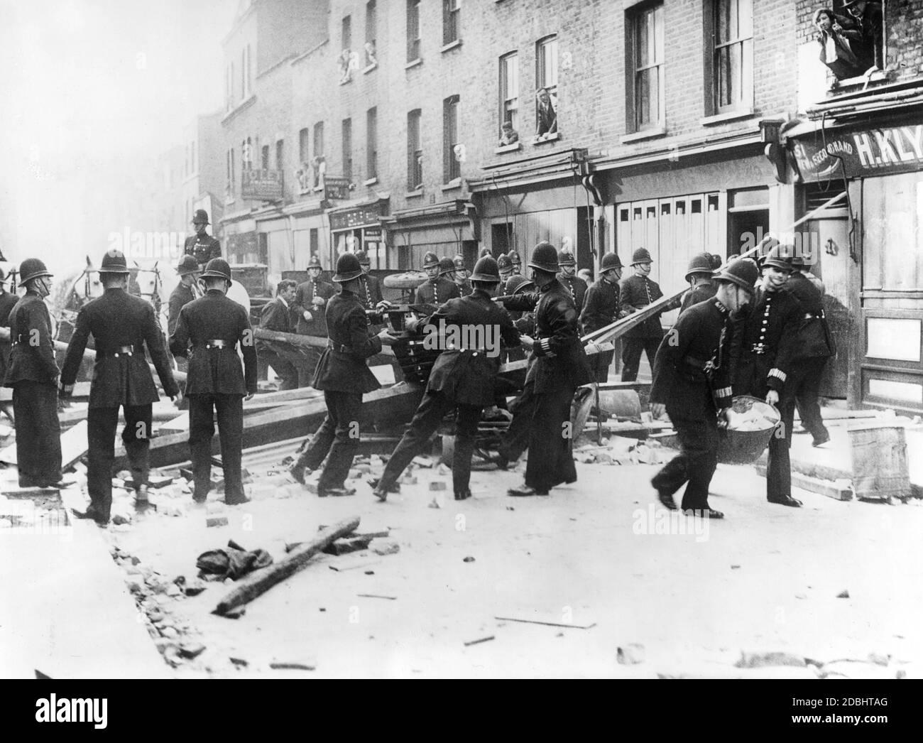 "Aufgrund eines verbotenen marsches der 'British Union of Fascists' (BUF) brachen im Londoner Stadtteil Whitechapel schwere Zusammenstöße aus. Polizeibeamte säubern eine zerstörte Straße." Stockfoto
