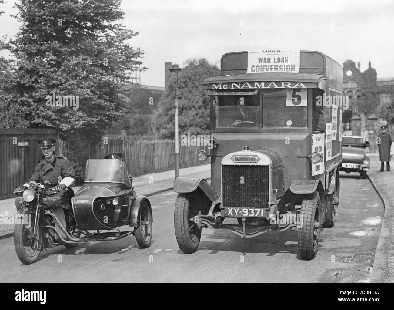 Von der Polizei bewachte Lastwagen bringen Formulare aus dem Regierungsdruckamt nach London. Die Formulare sollen die Anleiheinhaber über die durchgeführte Zinssenkung informieren. Stockfoto