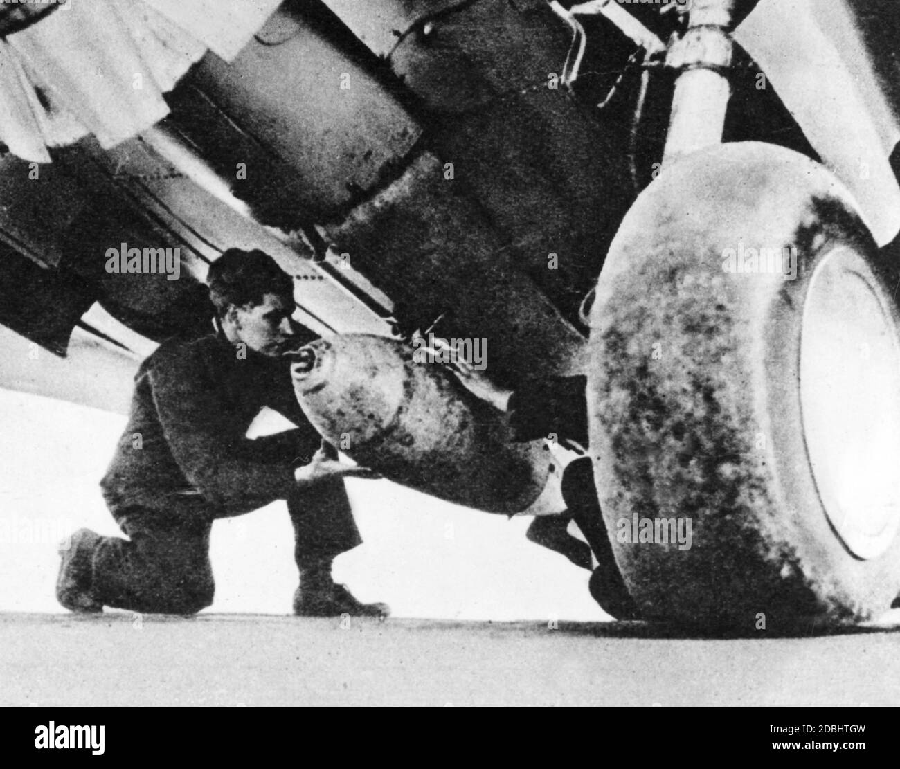 'Ein Soldat montiert eine Bombe auf einem US Curtiss P-40 ''Kittihawk'', der Missionen in Afrika unter englischem Emblem fliegt. (Undatierte Aufnahme)' Stockfoto