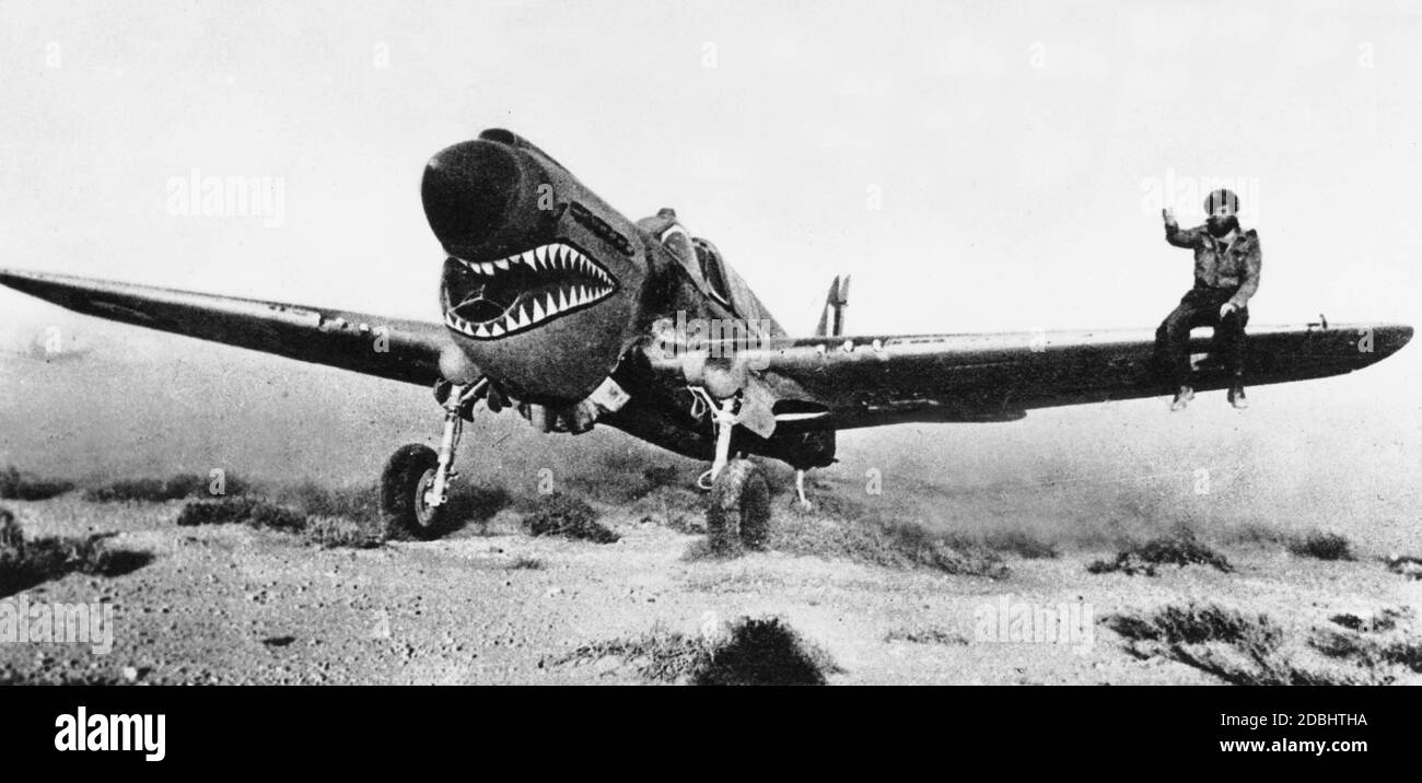 'Ein Pilot sitzt auf dem Flügel seiner Curtiss P-40 ''Kittihawk''. Das charakteristische Merkmal ist das gemalte '' Hai's mouth '''. Stockfoto
