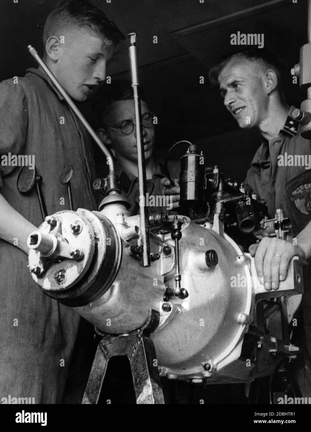 Zwei Mitglieder der Motor Hitler Youth werden über den Bau eines Motors erklärt. Stockfoto