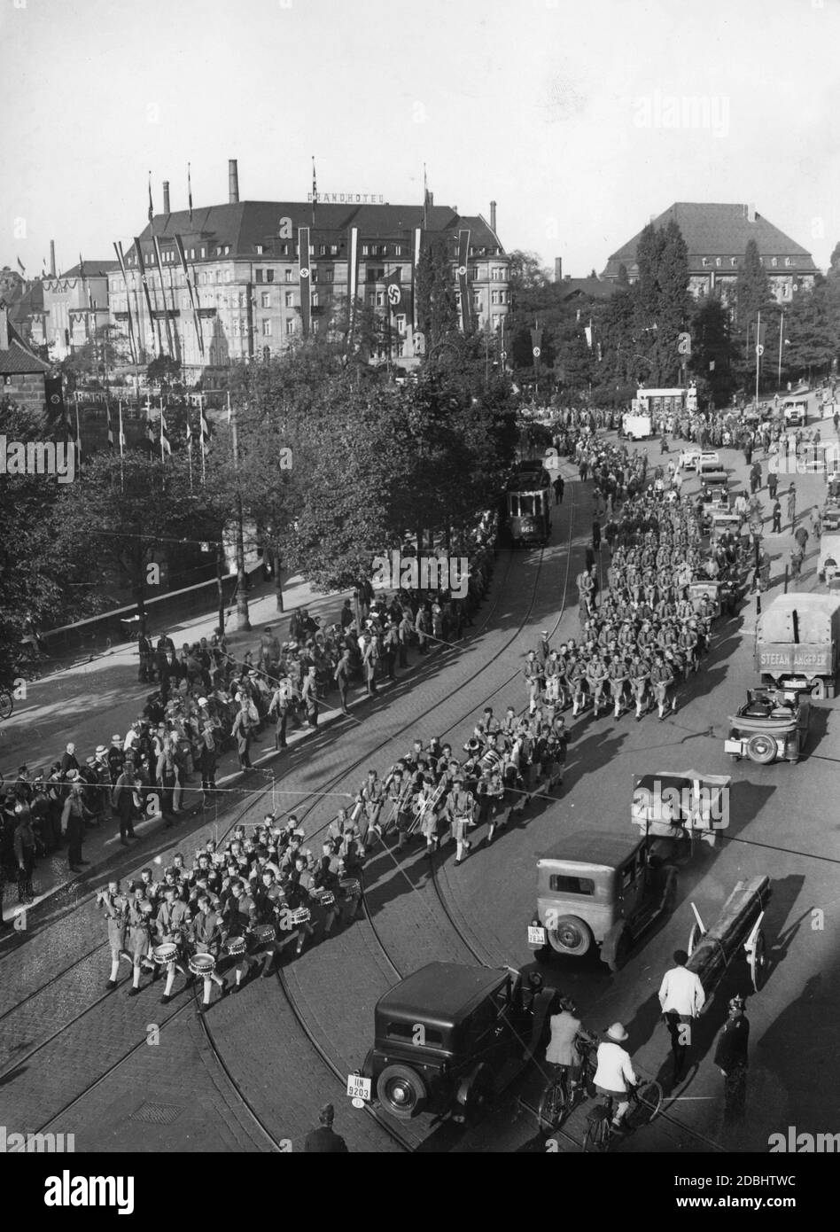 Blick auf die Parade der HJ-Formationen in Nürnberg, hier am Bahnhofsplatz. Vorne ist eine Musikabteilung mit Trommeln, Flöten und anderen Blasinstrumenten. Im Hintergrund das Grand Hotel Nürnberg. Stockfoto